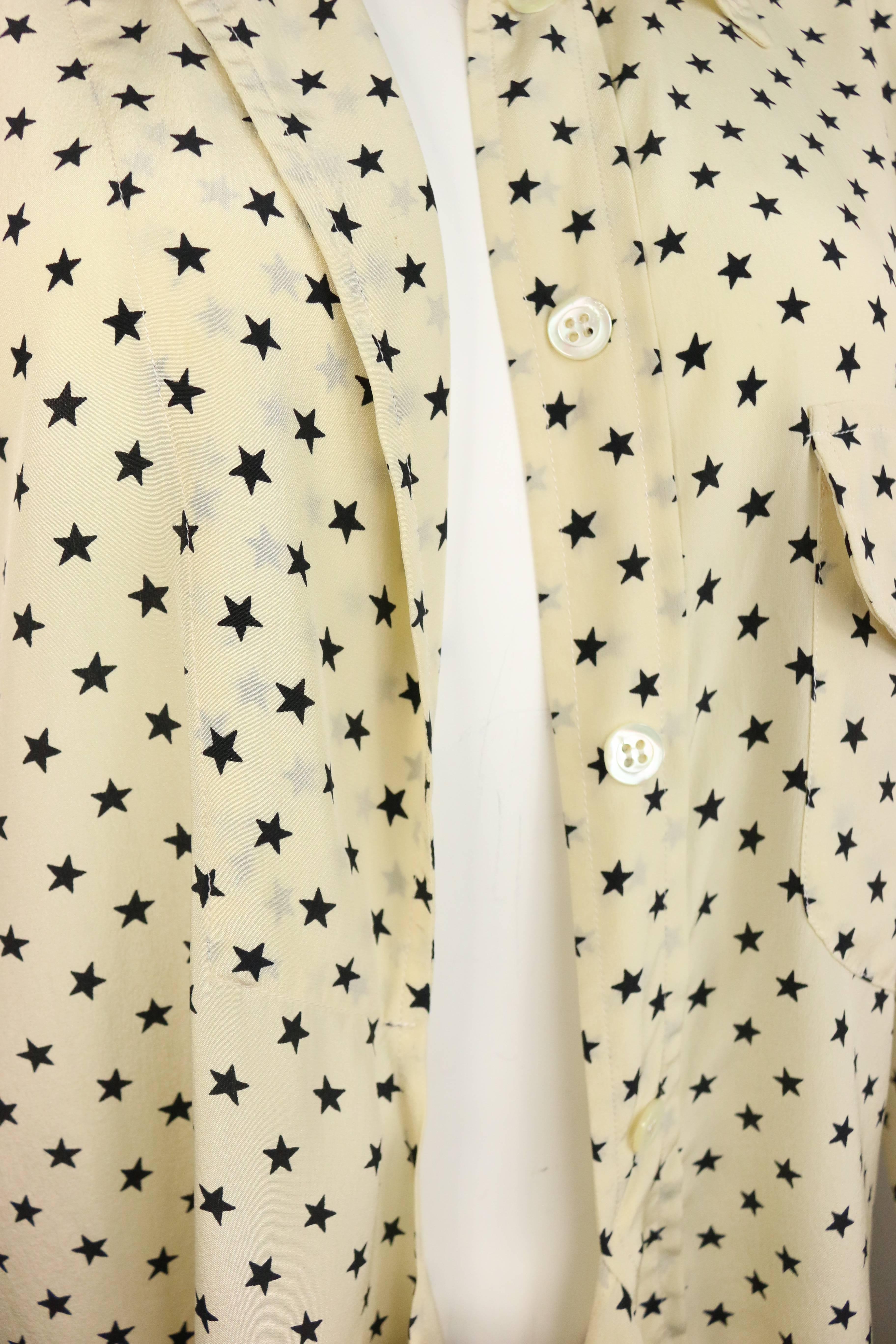 - Vintage 90s Moschino Couture elfenbeinfarbenes asymmetrisches Seidenhemd mit Sternchenmuster. Eine Seite des Hemdes ist kurzärmelig und ohne Knopfverschluss mit extra Stoff. Die andere Seite ist mit acht Knöpfen auf der Vorderseite, einer
