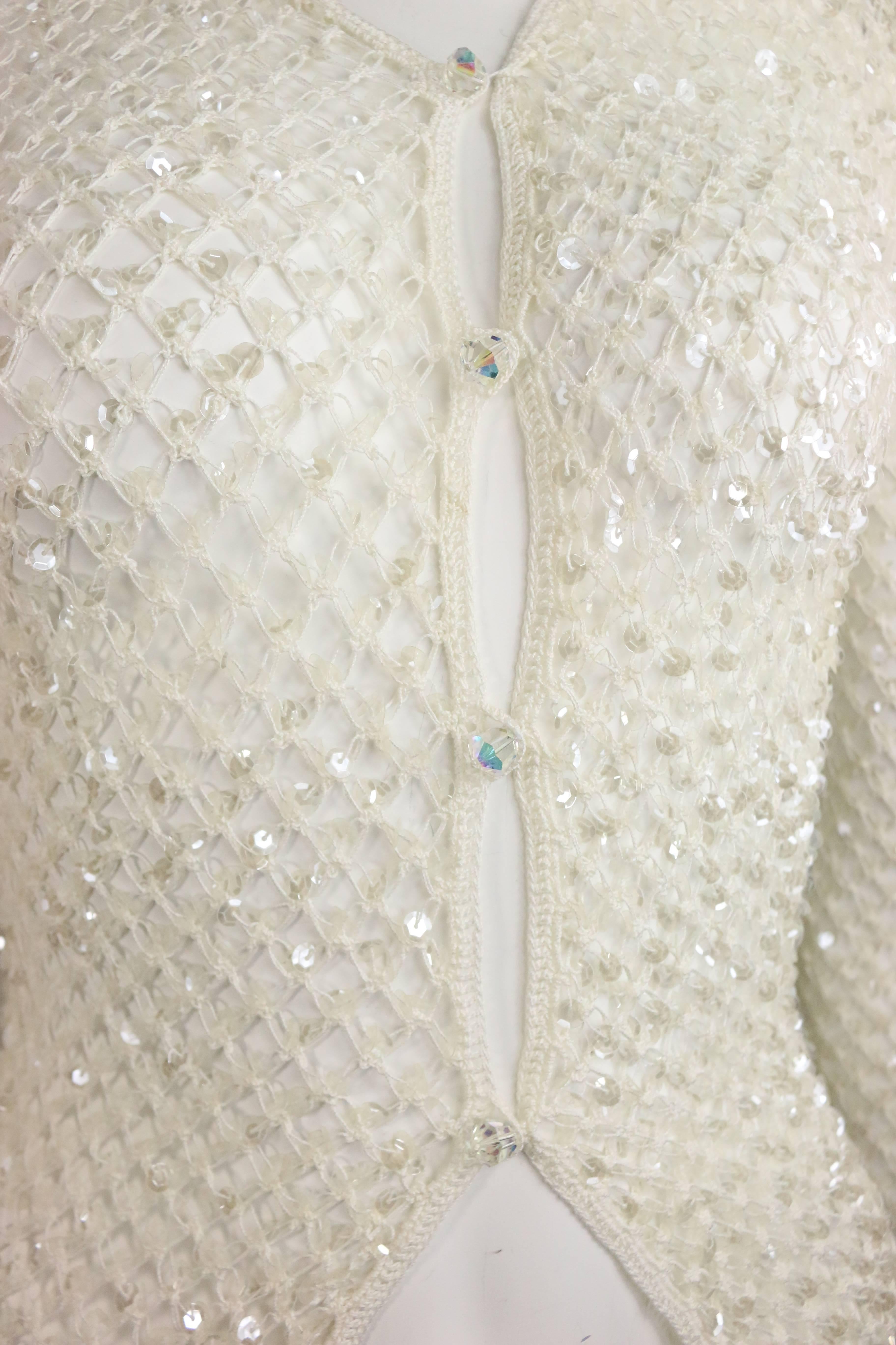 - Vintage 90s Dice Kayek white plastic sequin mesh net summer cardigan. 

- Featuring four front rhinestone buttons fastening. 

- Size M. 

- 70% Cotton, 20% Viscose, 10% plastic. 

- Height: 27in, Sleeve: 28in, Bust, 26-28in, Waist: 22in.
