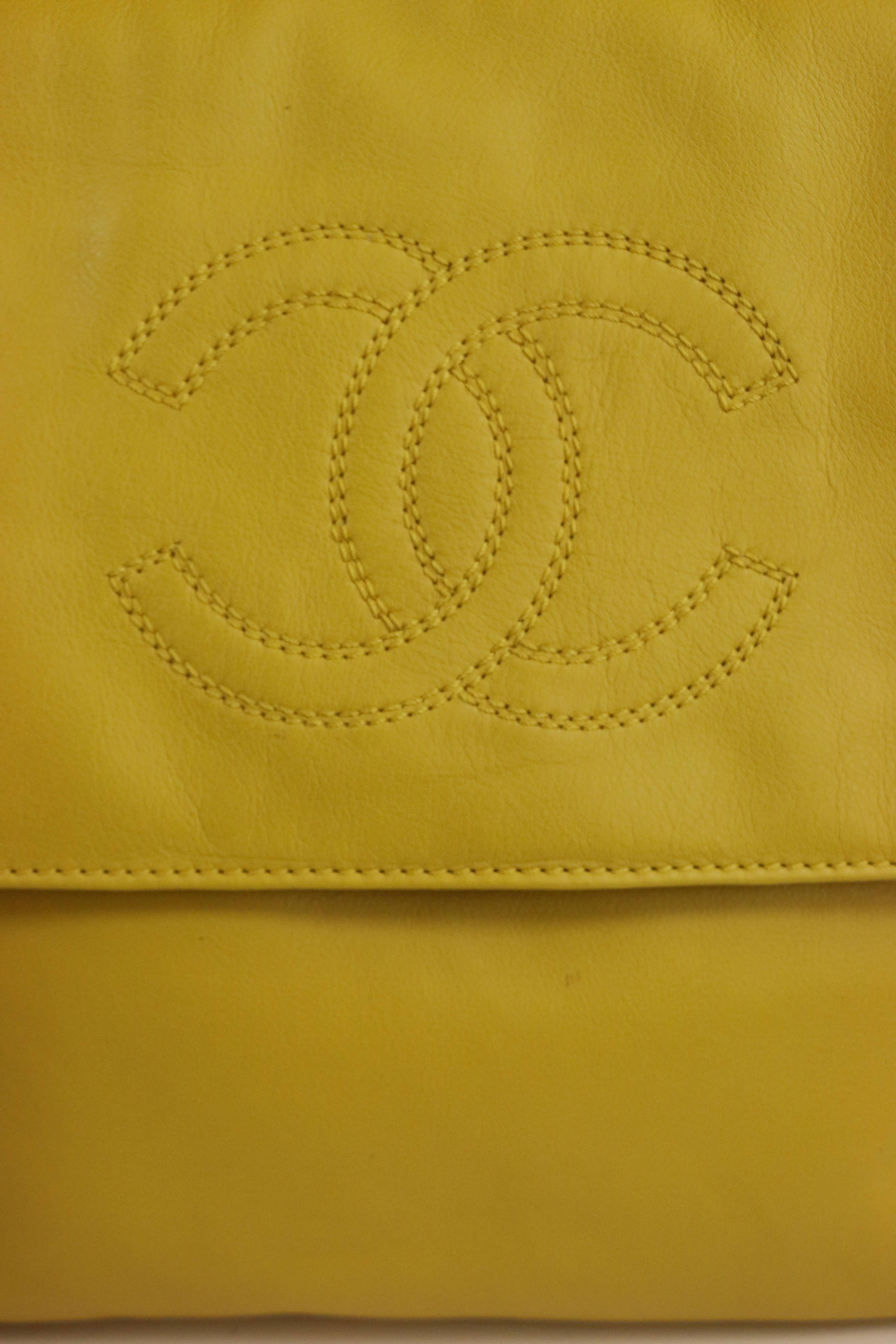 - Vintage 90s Chanel yellow lambskin leather shoulder strap flap bag. 

- Featuring "CC" stitching logo in front and one pocket at the back. Two interior zipper pockets. 

- Made In Italy. 

- Height: 9in, Length: 9in, Strap: 14in. 

-