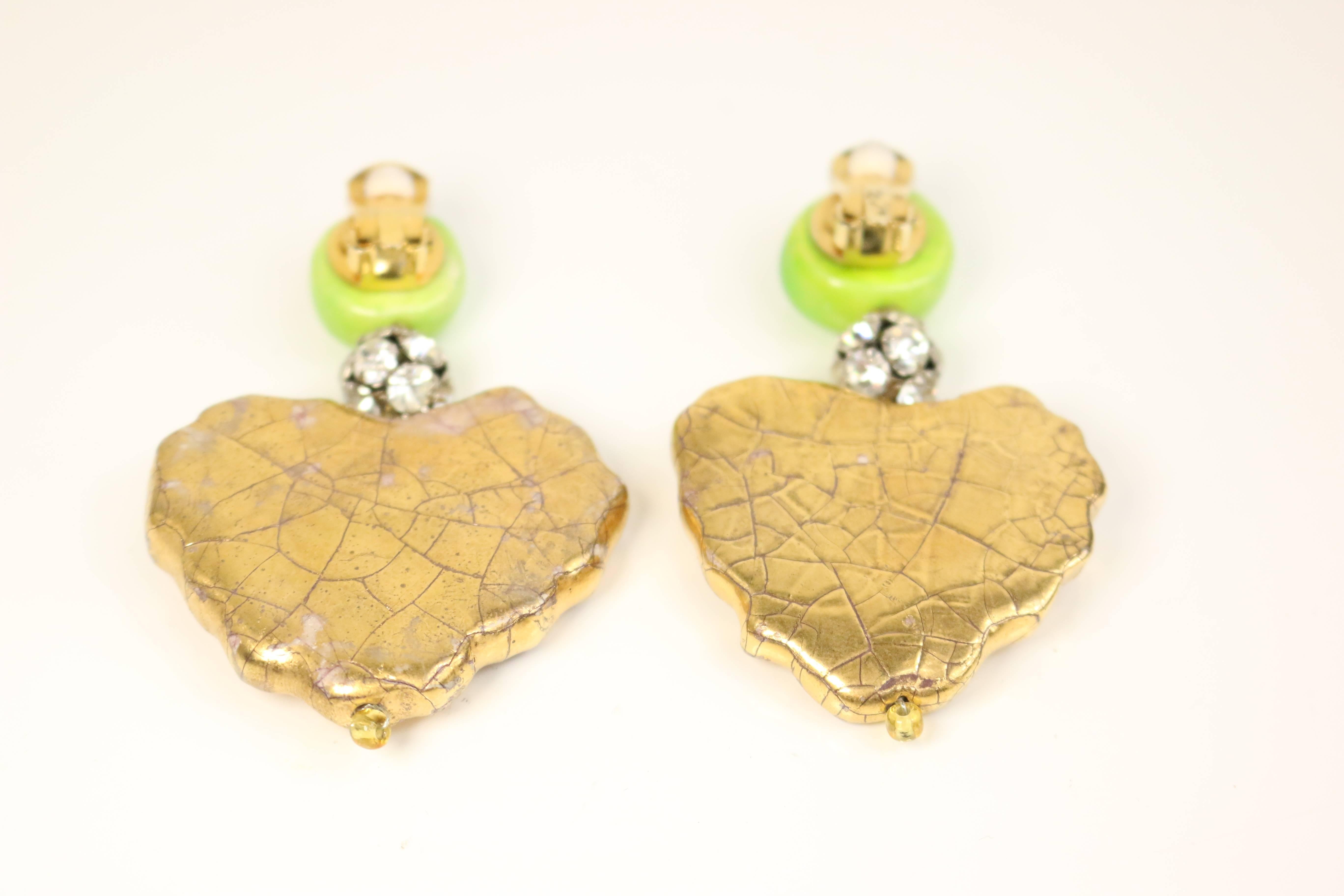 - Vintage 80s Christian Lacroix green gripoix drop gold tone heart shaped with green gripoix cross plate clip-on earrings. Each earring is in different shape and size, one bigger than the other. 

- Featuring silver rhinestones and cracked patterns