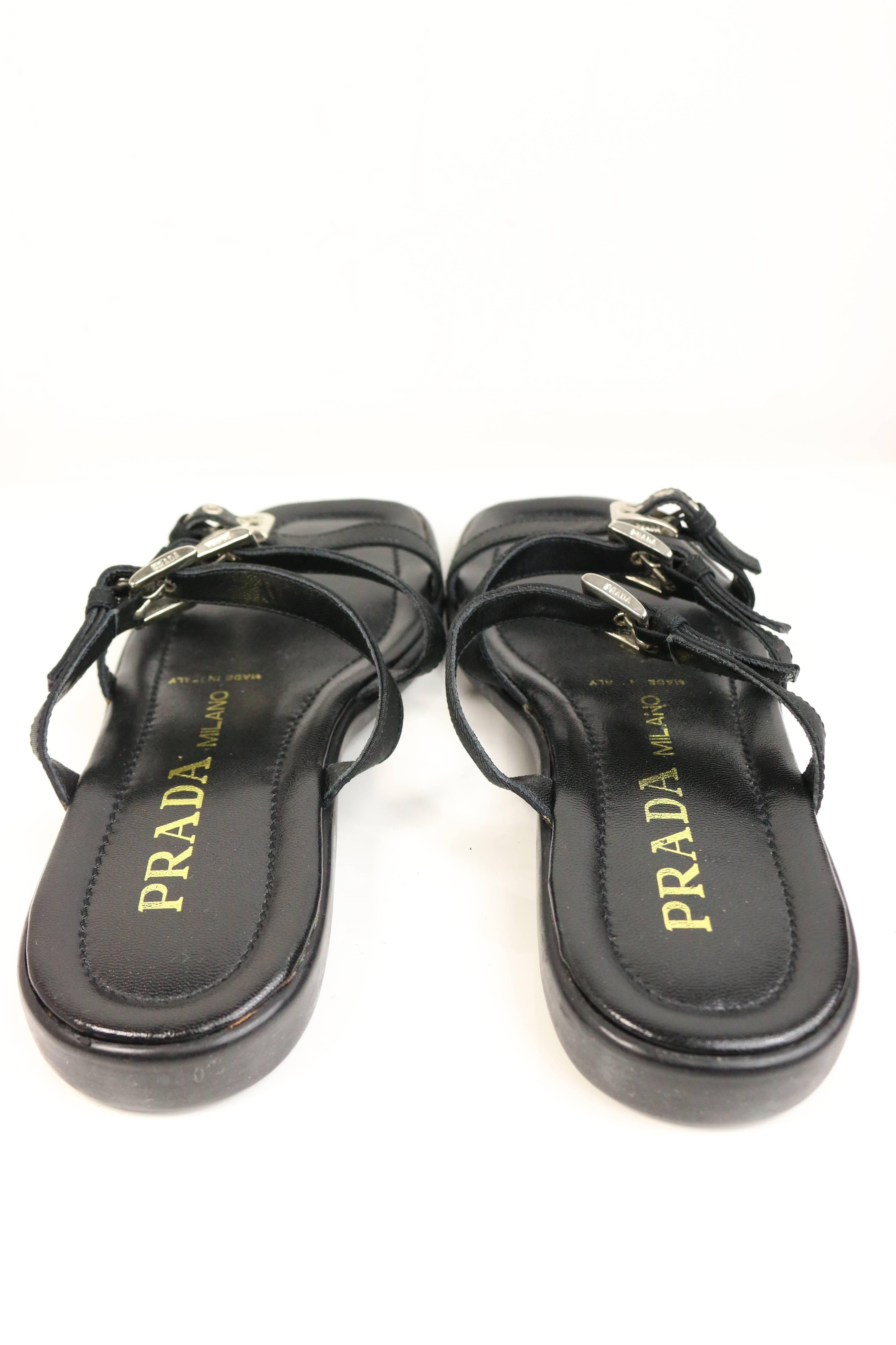 - Vintage 90s Prada black leather slip on sandals. Featuring three black nylon straps with sliver adjustable buckles.

- Made in Italy. 

- Size 38.  

- Please note this vintage item is not new, so it might have minor imperfections.

