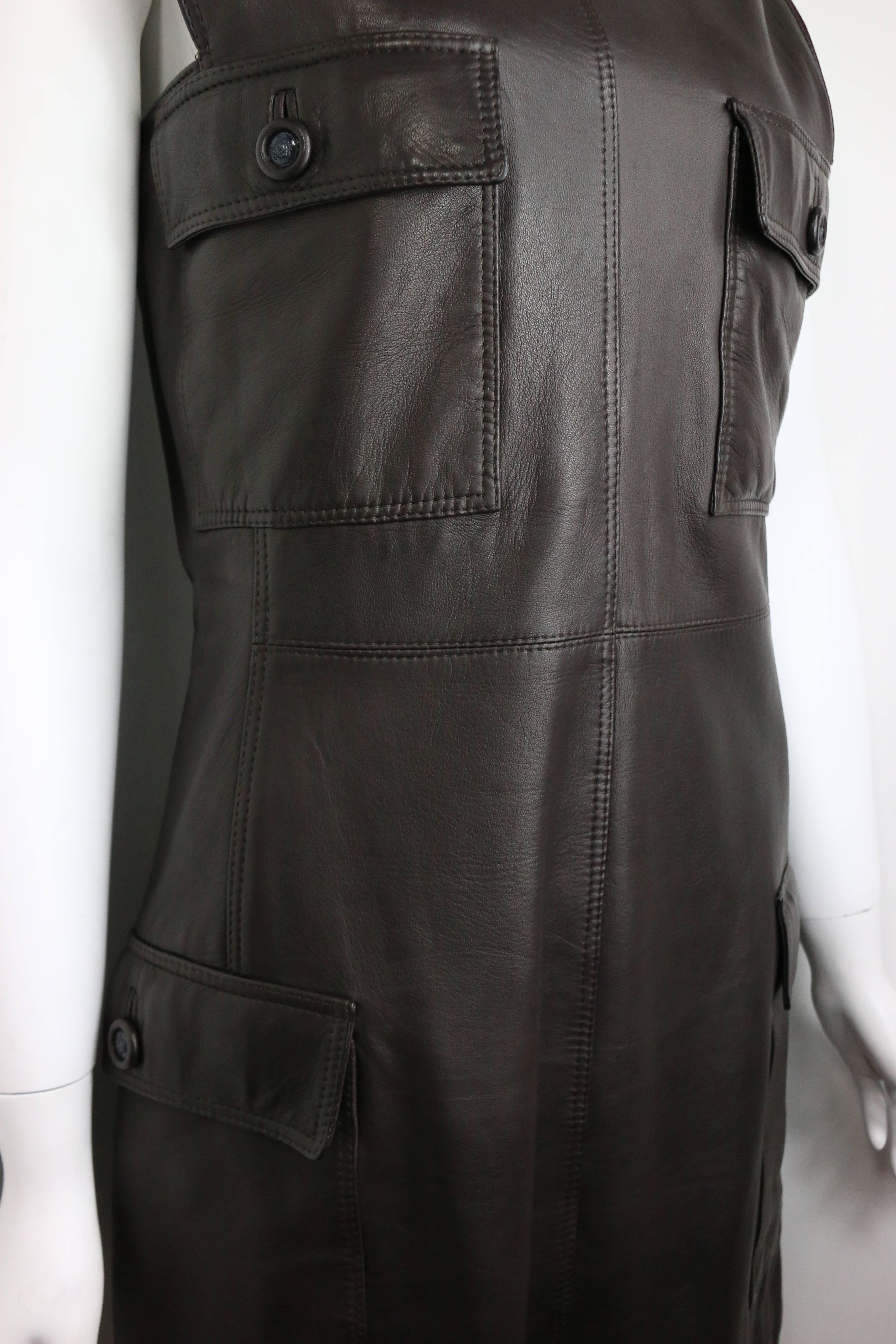 - Vintage iconic 90s Gianni Versace brown leather dress. 

- Featuring four pockets with signature medusa buttons. 

- Back zipper closure. 

- Made in Italy. 

- Size 40. 

- Length: 33 inches. Bust: 32 inches. Waist: 30inches. 

- 100% Leather.