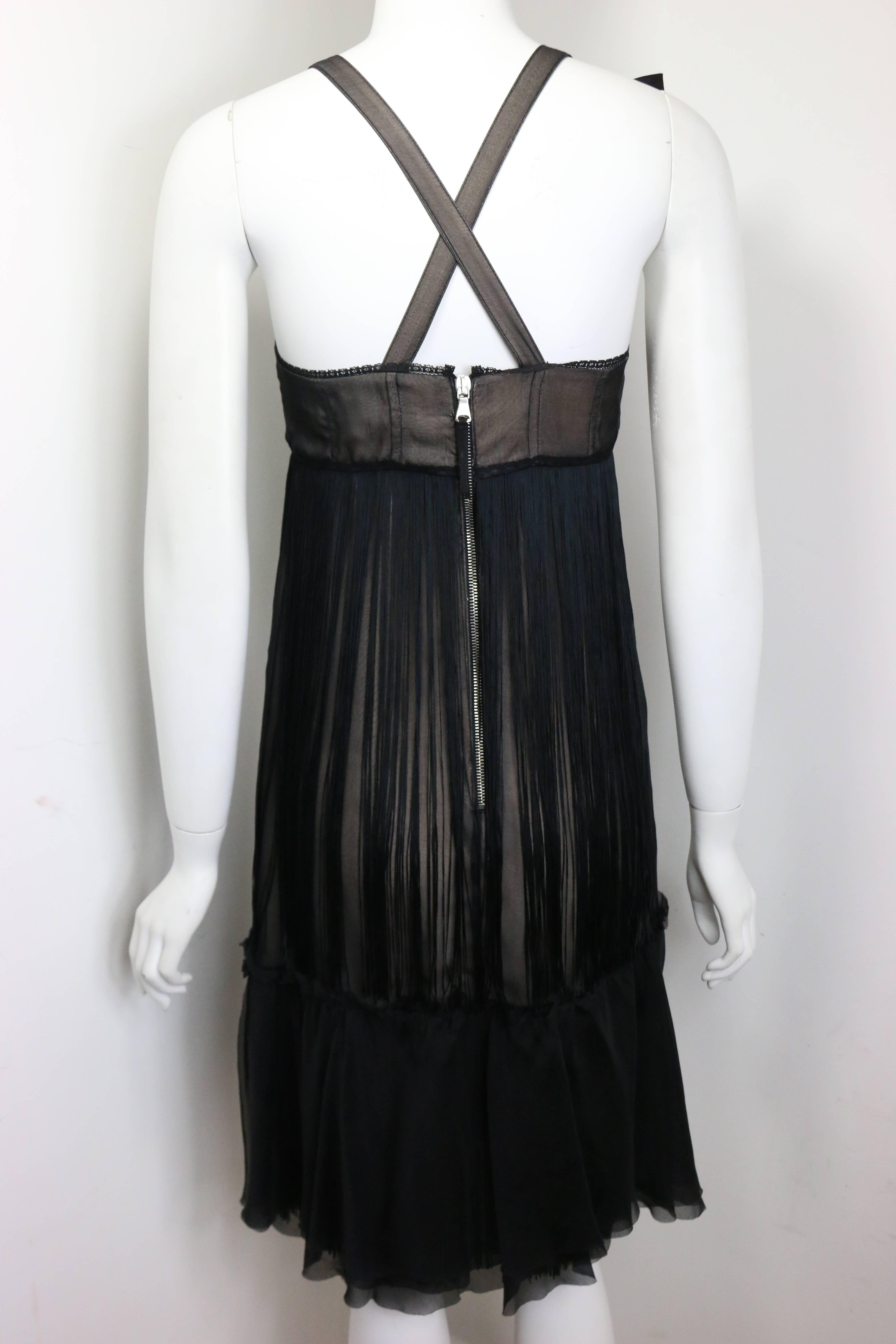 - D&G by Dolce & Gabbana black sheer silk cocktail dress. 

- Featuring a black bow ribbon on the right spaghetti strap. Flesh coloured silk underlining and black sheer silk layered on top with fringe. Silver zipper at the back fastening. 

-