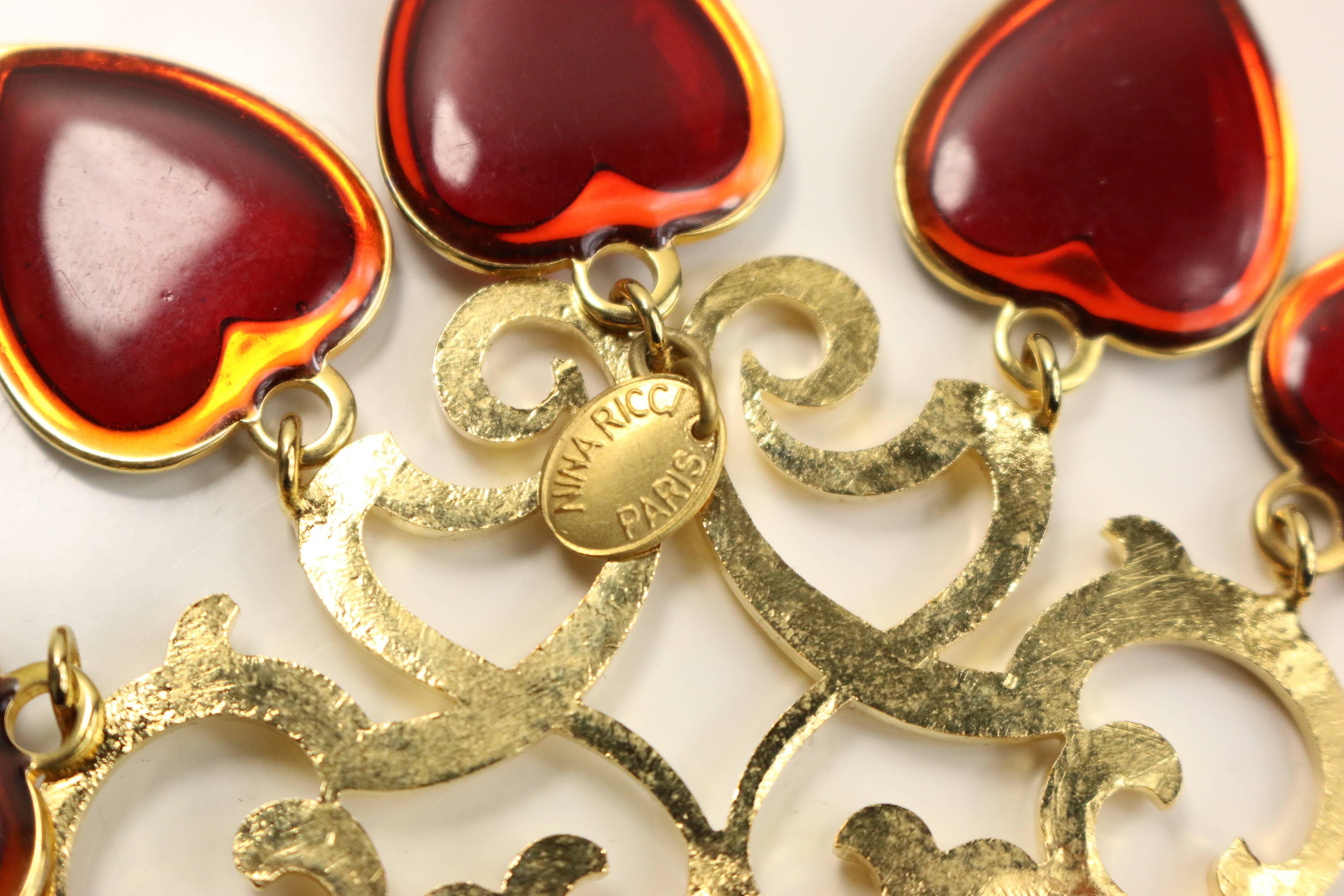 - Vintage 80s Nina Ricci red hearts gold toned setting statement clip on earrings. Featuring  gold toned heart shaped patterns attached with five red hearts dropping on each earring. This is one of a kind design! Its chunky, its chic and its a