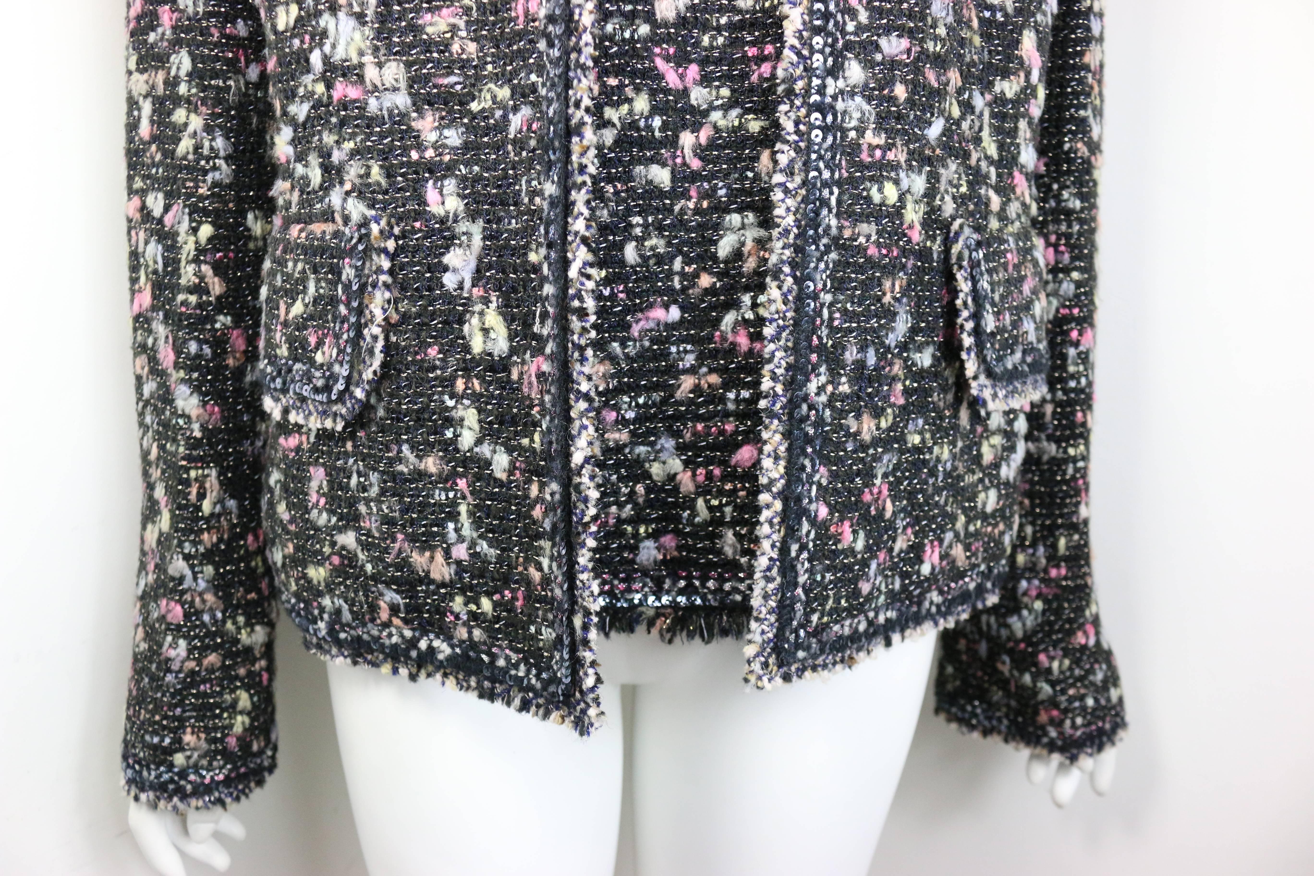 - Giacca in tweed di lana multicolore e top con maniche di Chanel della collezione Autunno 2004. La giacca è caratterizzata dallo stesso tessuto e dalla spilla in tweed colorato. Collo alto senza bottoni, due tasche con patta e tre bottoni neri 