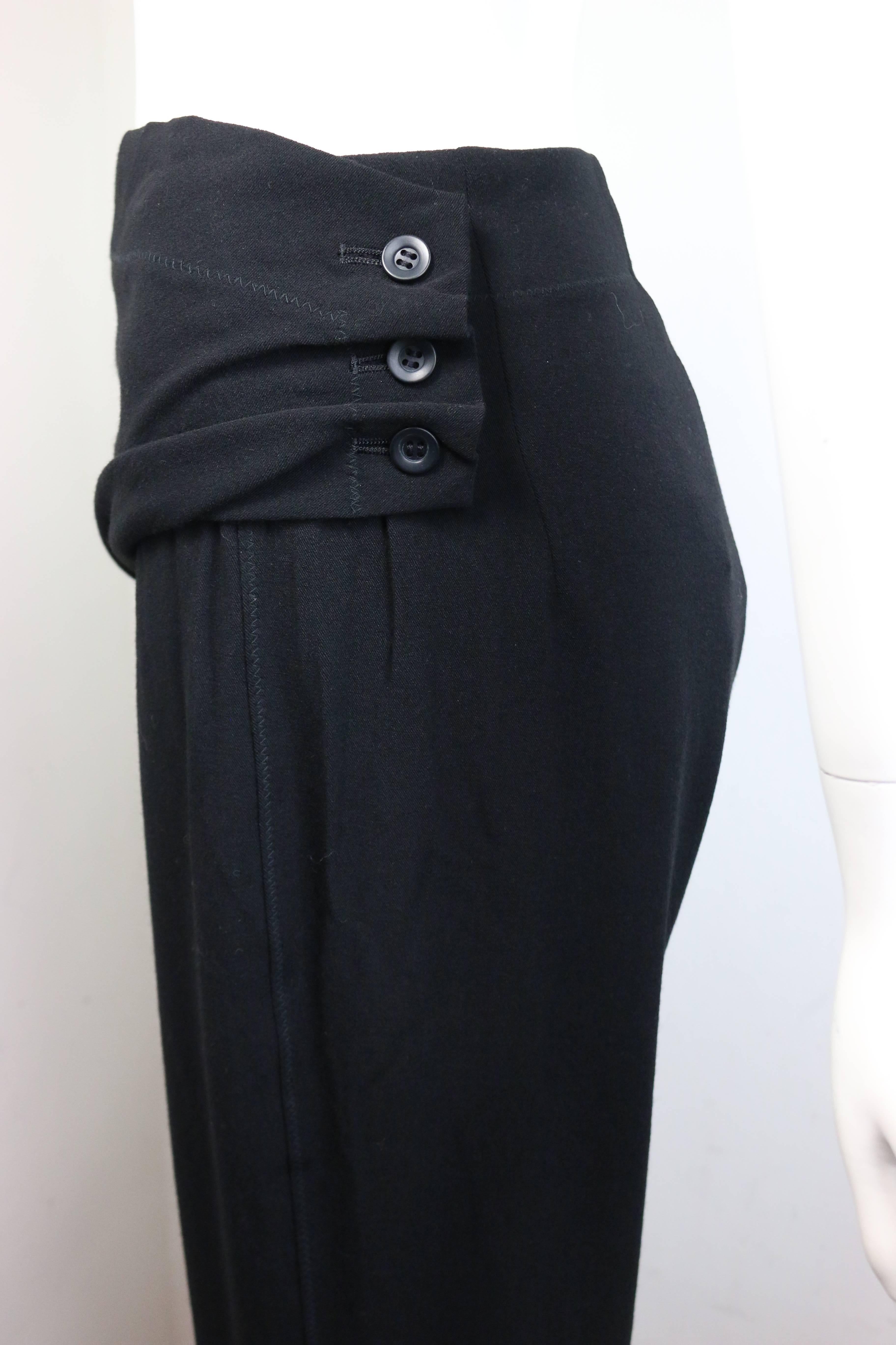 - Vintage 90s Issey Miyake black wool straight legs and wide on the bottom pants. Featuring a three buttons wrap design in front. A sew stitches detail on the right of back the knee area. It is a subtle black pants with details. A collectible item.