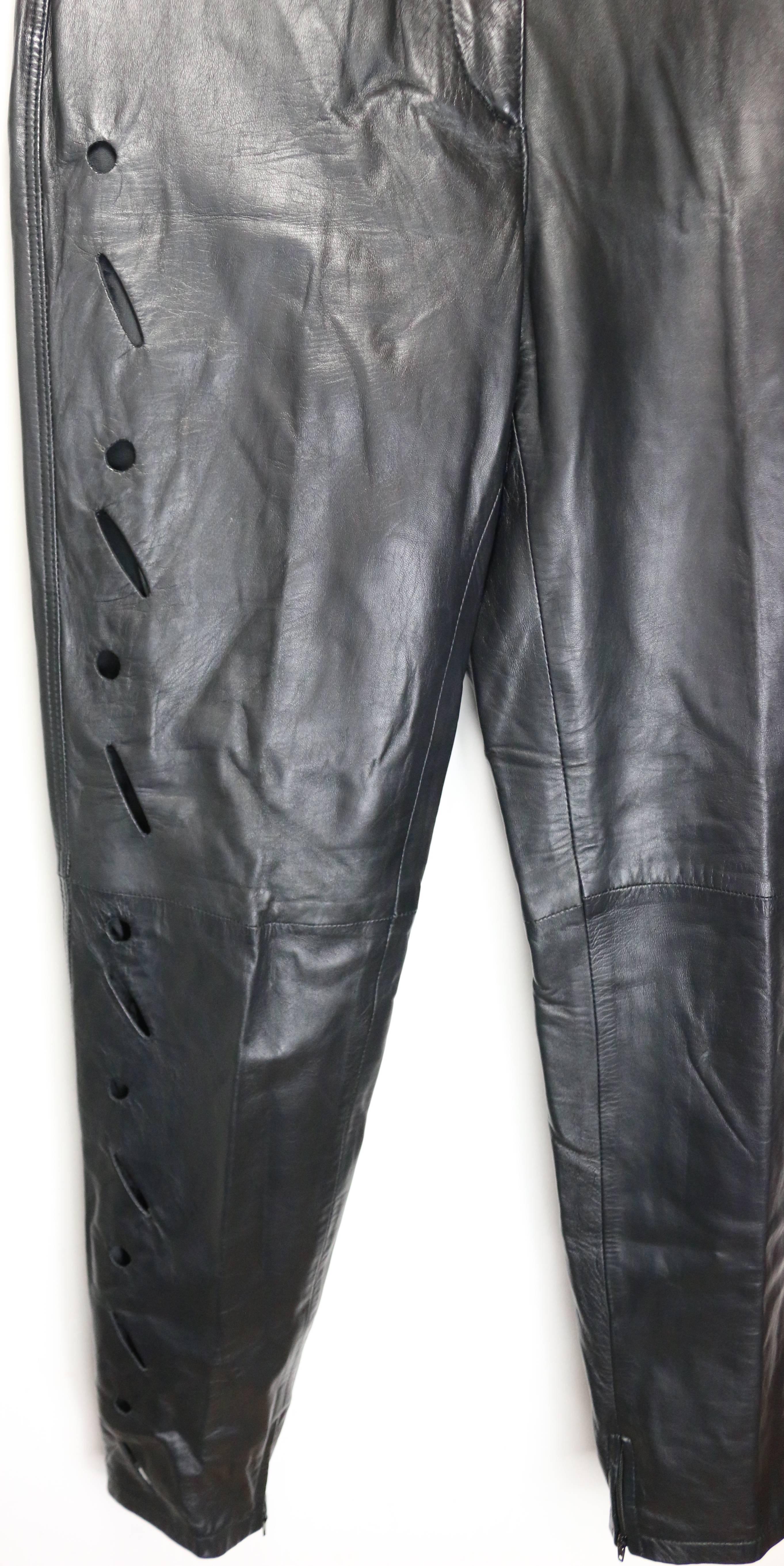 - Vintage 90s Istante by Gianni Versace black leather with cutout pattern pants. It is a slim tapped leg cut style.  

- Featuring right leg front, left leg back and back pockets cutout patterns.  Zipper on the bottom inner leg hem. 

- Made in
