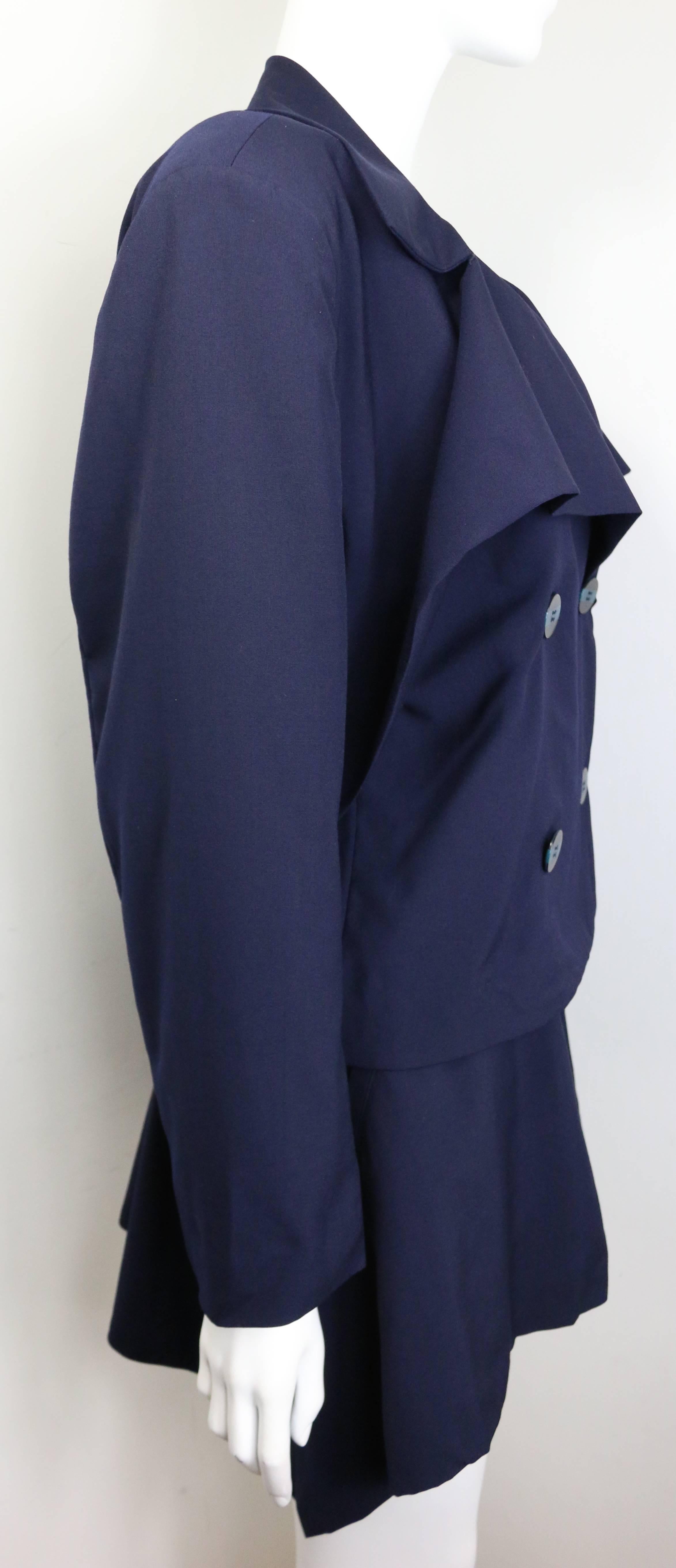 - Vintage 80s Issey Miyake navy blue double breasted jacket and skirt ensemble. 

- Jacket: Four front black with blue stripe buttons fastening. Wide collars. Back strap with two black blue stripe buttons. 

- Skirt: Irregular hem skirt with four