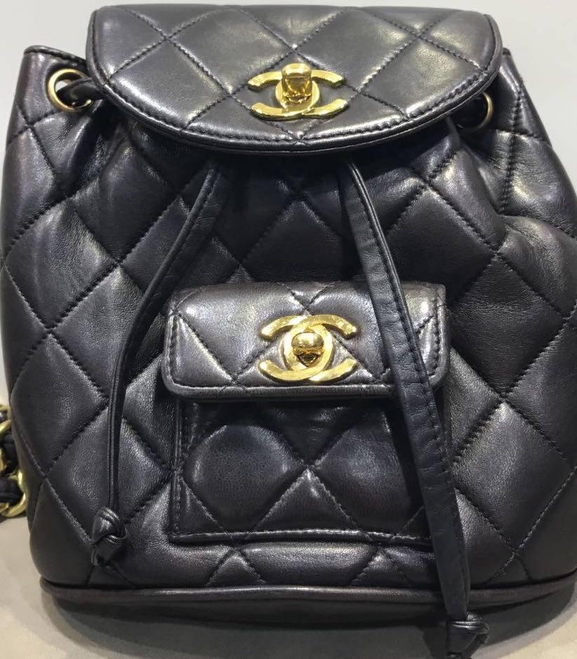 - Vintage 90s Chanel black quilted lambskin leather mini backpack bag with gold chain hardware leather straps. Its a chic , luxury and sophisticated and still modern looking for now!  

- Featuring a gold toned "CC" turn lock closure with