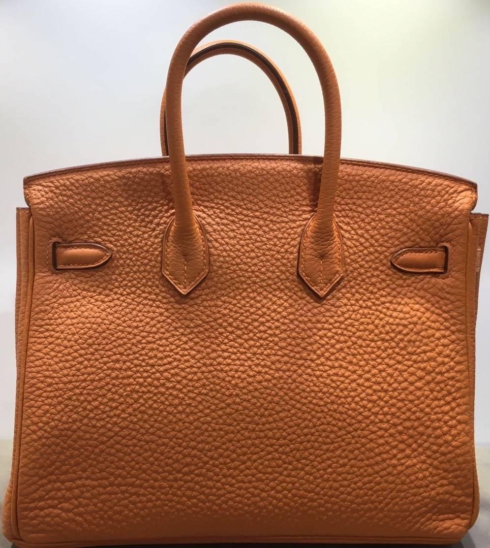 - Brand new and 100% authentic Hermes Birkin 25cm togo leather comes in stunning orange colour from year 2014. Featuring silver toned hardware and a silver lock on the front side of the bag. It is also fitted with silver metal feet and a flawless