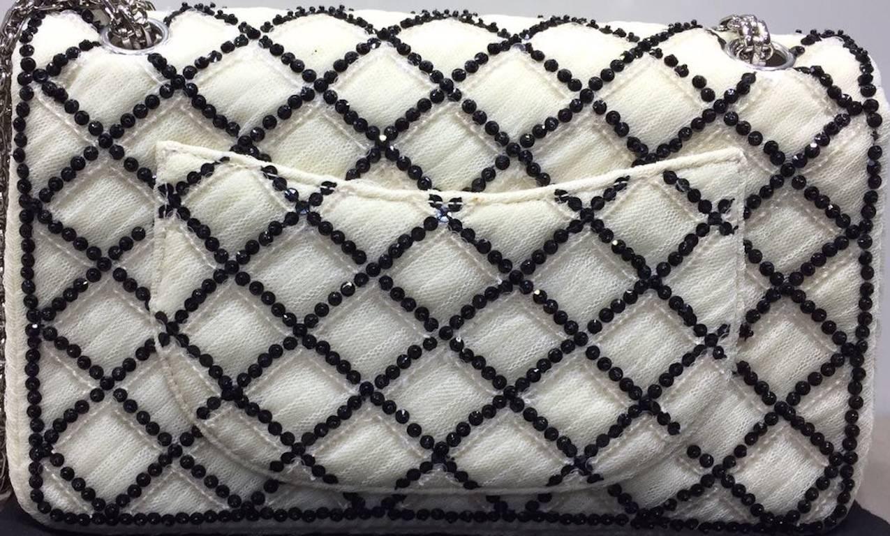- Chanel  black and white cotton sequined flap shoulder bag. 

- Featuring a turn lock closure, a chain shoulder strap, a quilted effect, a back slip pocket and an internal slip pockets. 

- Made in France. 

- Measurements: Length: 24 cm. Height: