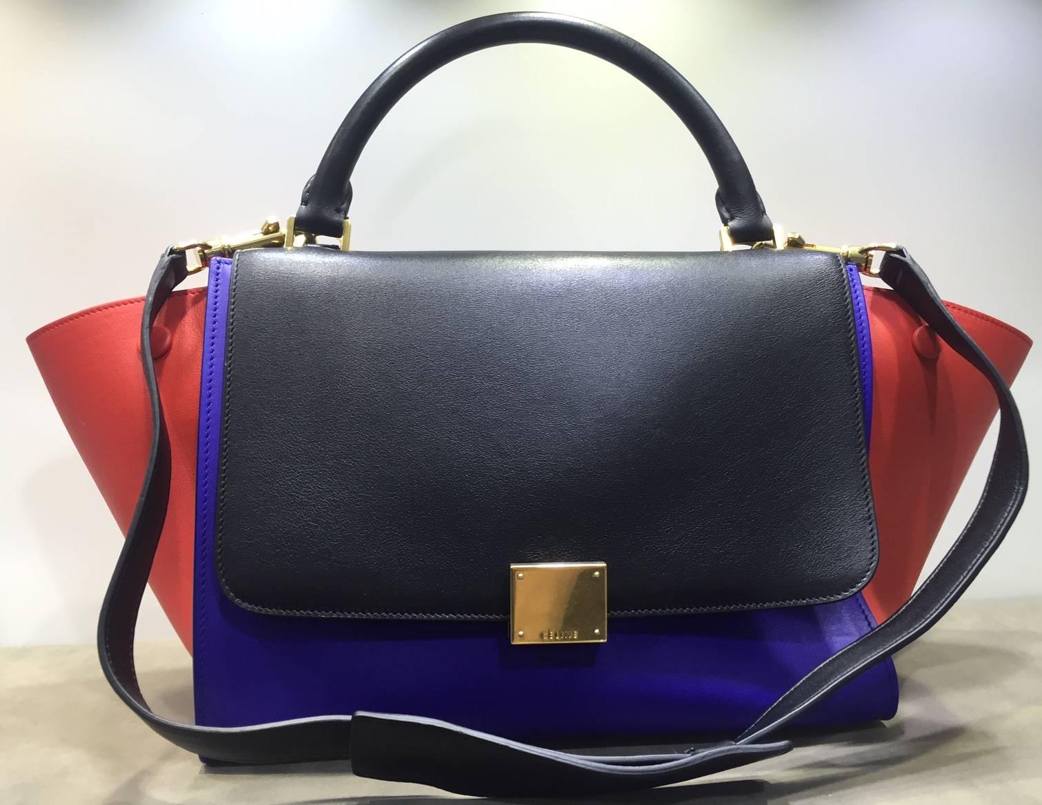 - Celine tri colour (black, midnight blue and red) trapeze leather luggage tote bag  with strap from spring 2014 collection. The use of colours and the colour combination are like looking at an art piece directly!  It doesn’t come with a long
