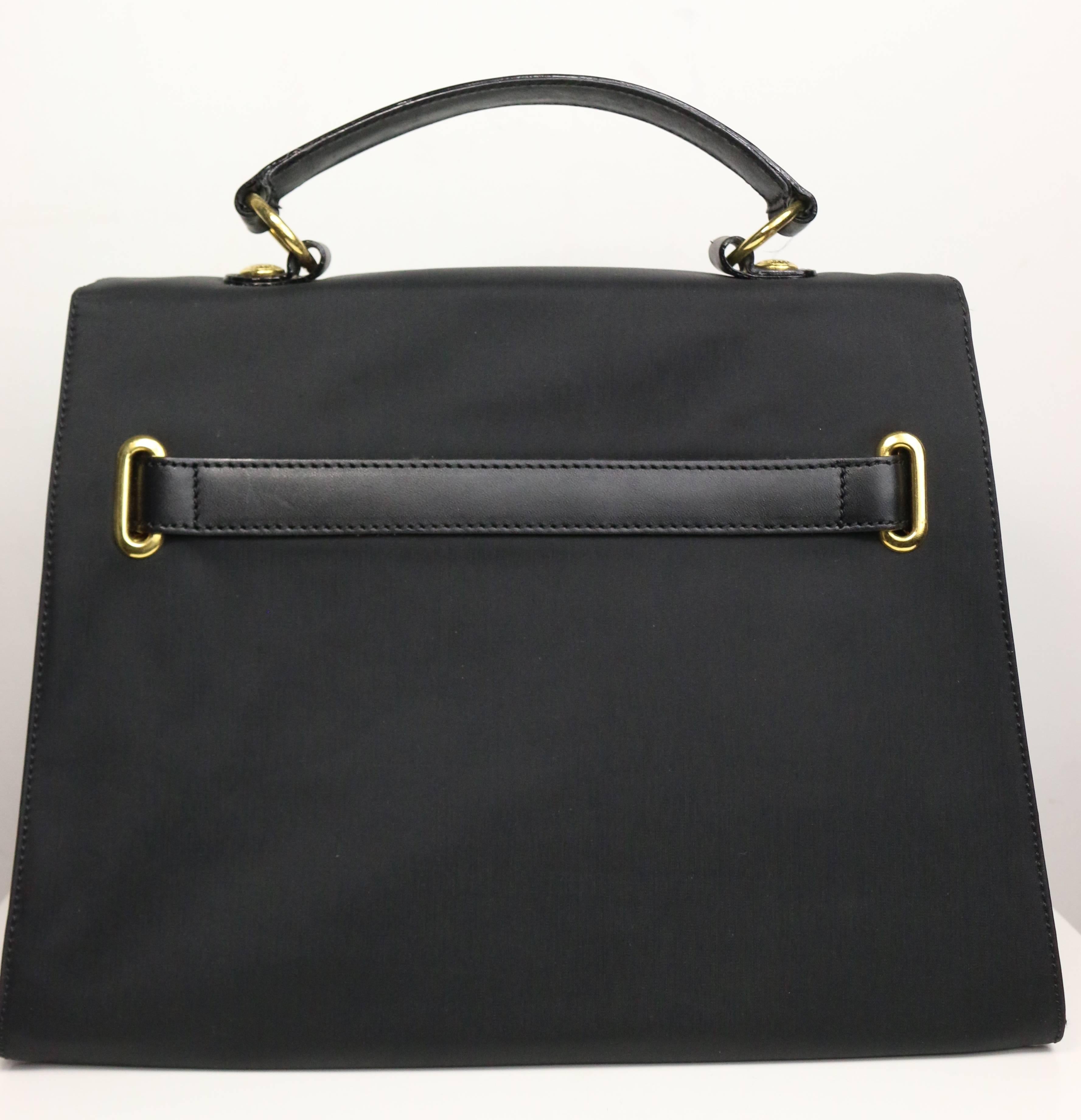 - Vintage 90s Moschino black nylon kelly style bag. This bag is made in Italy by RedWall. Featuring a gold hardware interlock closure, black leather handle and interior 