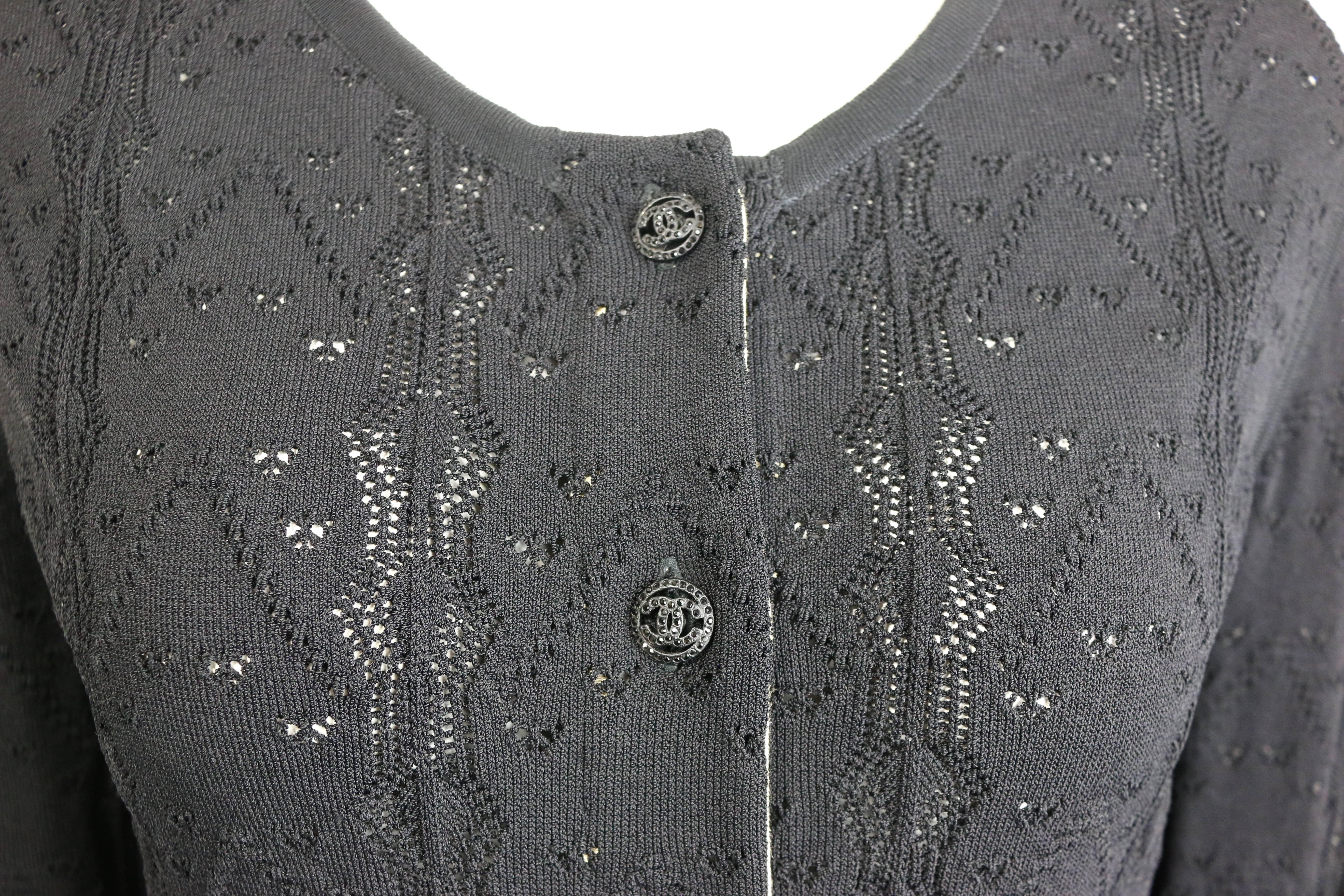 - This is a cardigan sweater by Chanel, from 2008 pre collection.  This sweater features a black crochet knit in heart pattern and a horizontal stripe ruffle bottom. Featuring six shiny black rhinestones 