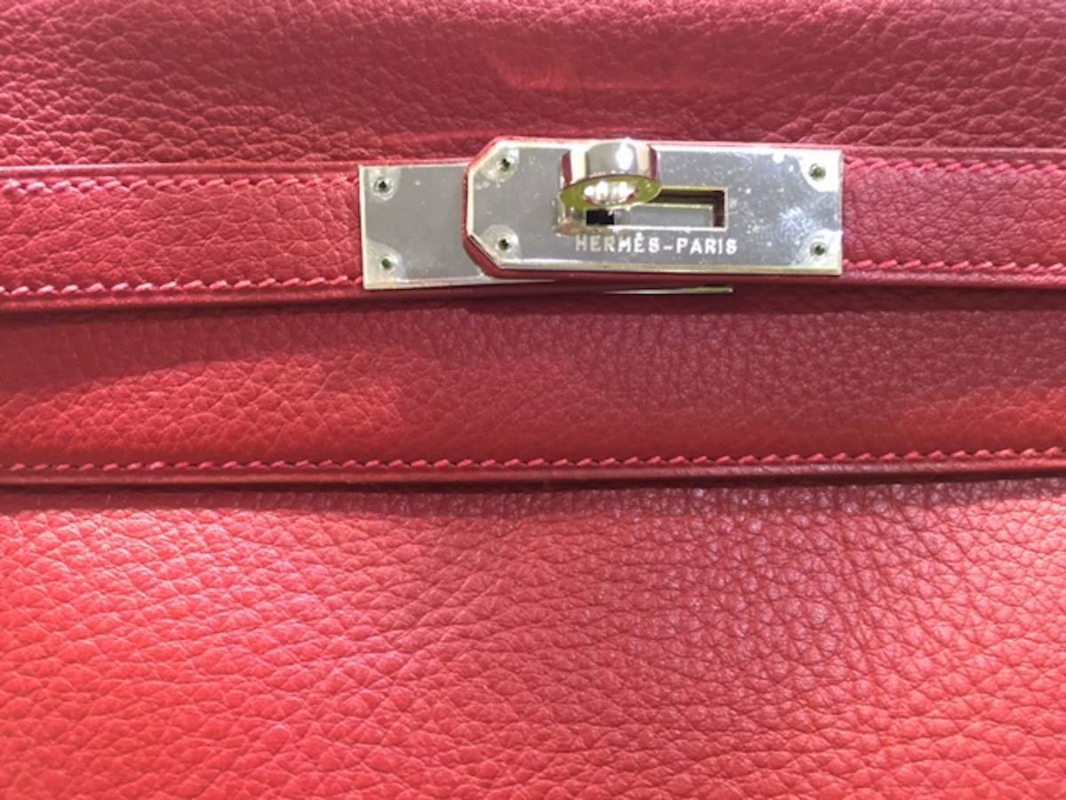 - This Hermes 32cm Kelly Retourne is a classic! This bag is made of lovely Rouge Garance red clemence leather, and paired with palladium-plated hardware.  A matching shoulder strap allows the Kelly to be shown off on your arm or shoulder. Also, the