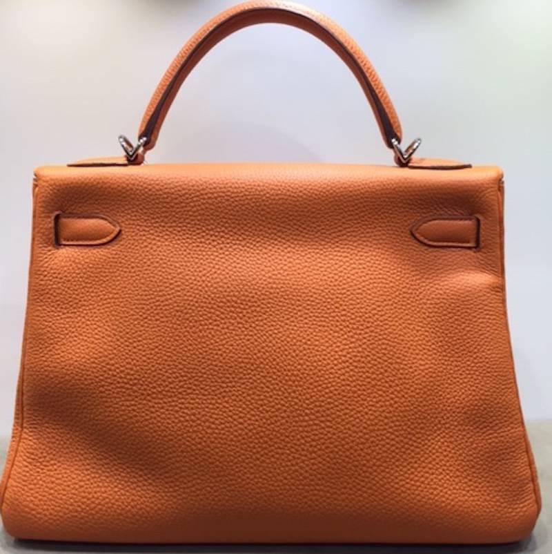 - This Hermes 32cm Kelly Retourne is a classic! This bag is made of lovely orange soft Togo leather, and paired with palladium-plated hardware.  A matching shoulder strap allows the Kelly to be shown off on your arm or shoulder. Also, the interior
