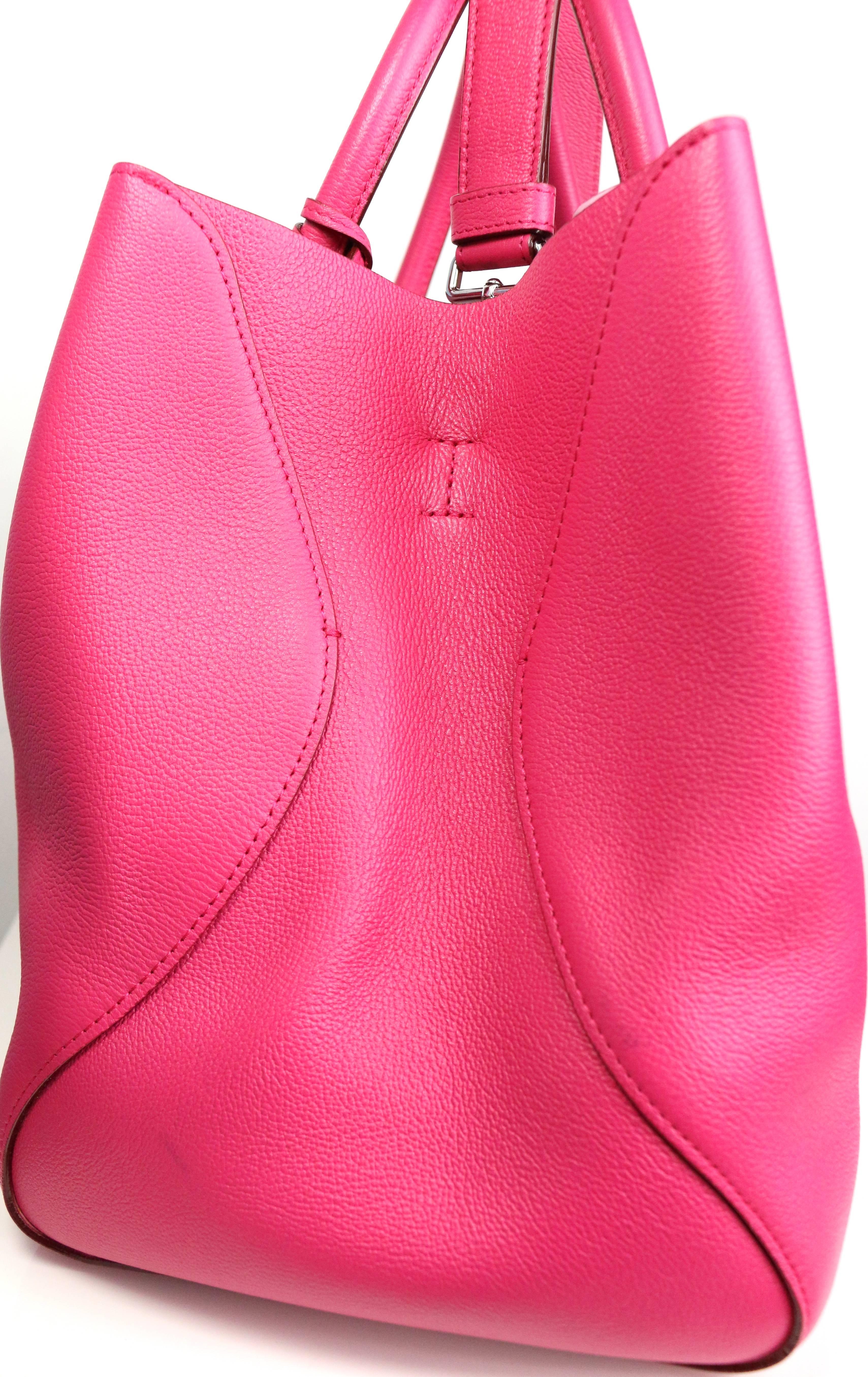 - This beautiful Christian Dior pink supple grained calfskin with polished silvertone hardware. Open top with optional clasp tab detail. Featuring Clip removable and buckle adjustable  Interior features leather lining with three slip pockets and one
