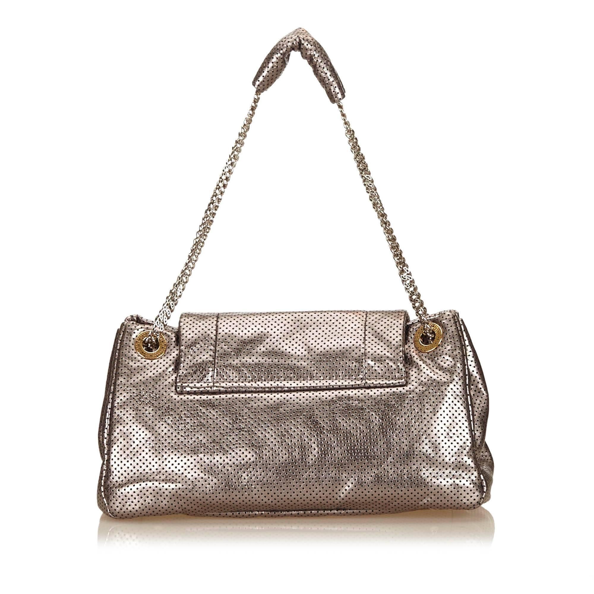 - This Chanel grey flap drill accordion 2.55 reissue shoulder bag features a perforated metallic leather body, silver-tone chains, a front flap with a twist lock closure, and interior zip and open pockets. 

- Made in France.

- Length: 34cm.
