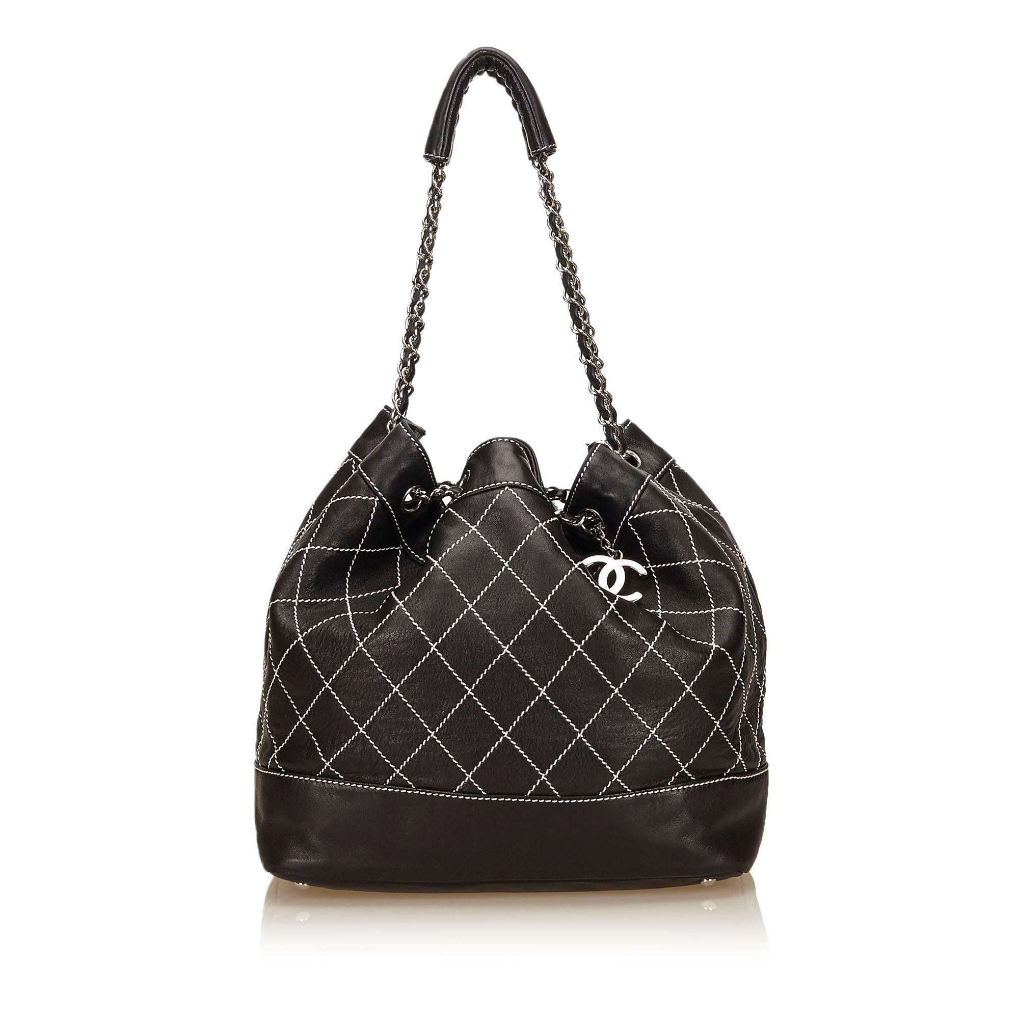 - This Chanel black and white wild stitch drawstring shoulder tote bag featuers a leather body, a silver-tone hardware, and an interior zip pocket. The bag has silver eyelets through which silver chain link straps are threaded and has leather