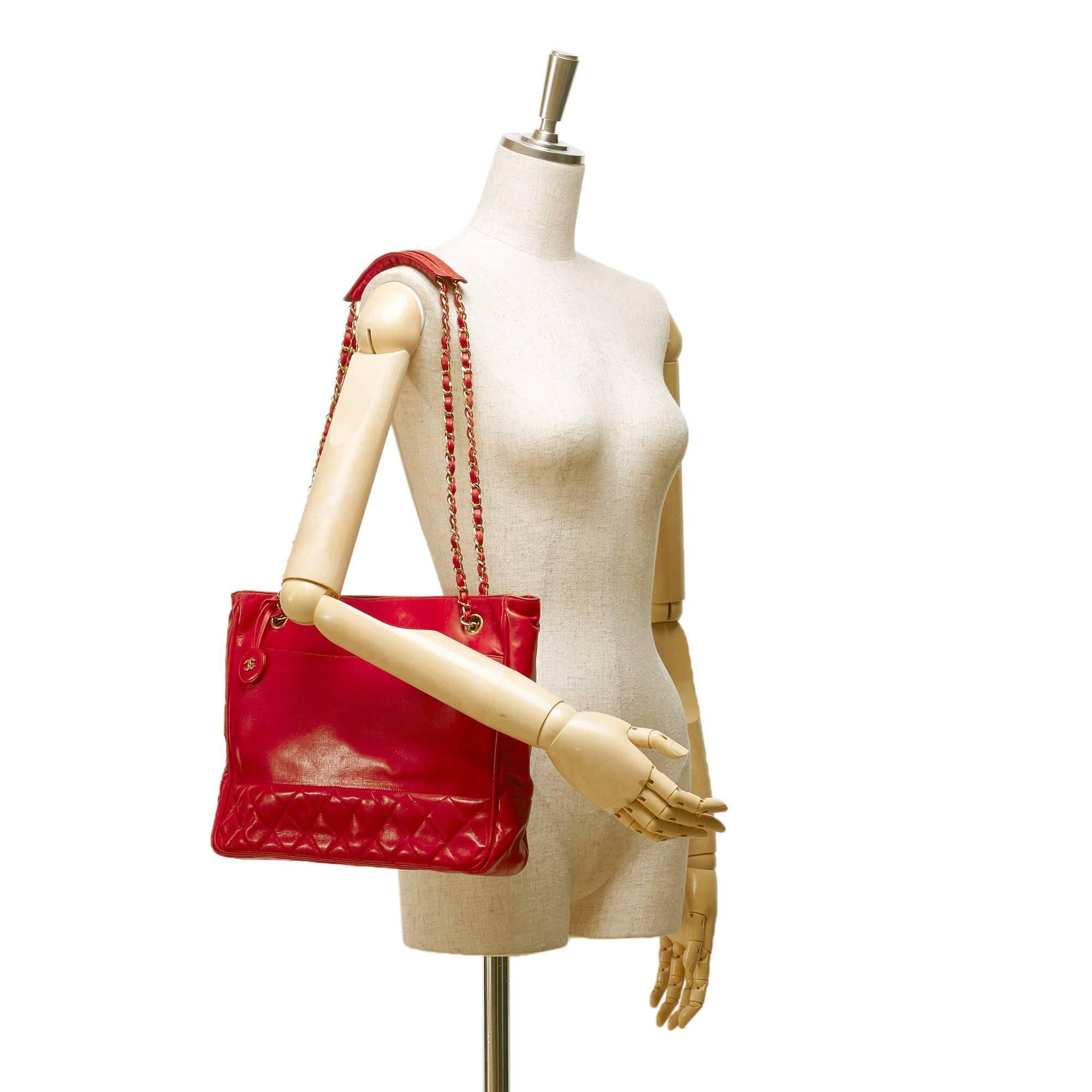 - This Vintage late 80s Chanel red lambskin leather shoulder bag features gold toned chain, exterior slip pocket, open top with magnetic closure, and interior zip pockets. This rare and more than 30 years Chanel bag is one of a kind. 

- Made in