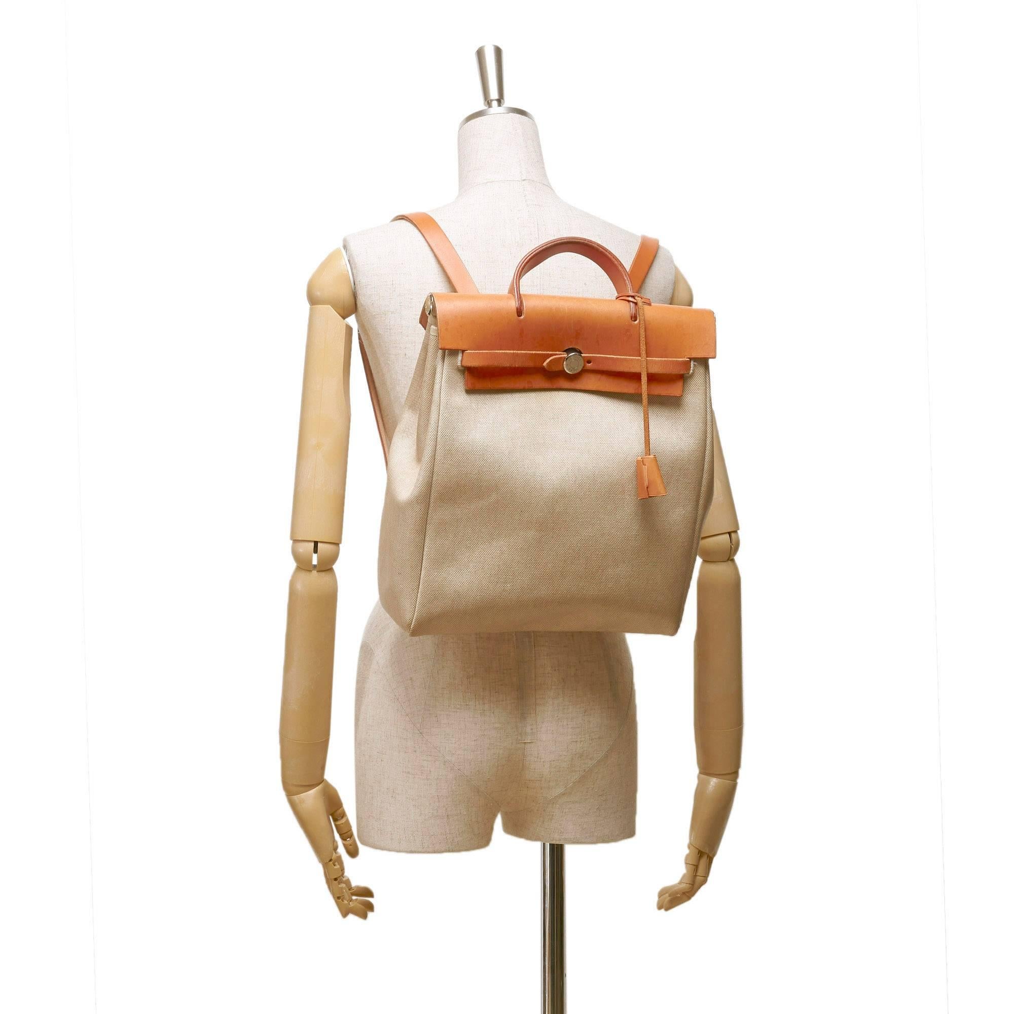 - Vintage 1998 Hermes Herbag Pm backpack features a white canvas body, a tan leather front flap, flat leather back straps and a belt strap closure.

- Made in France. 

- Size: 29cm x 33cm x 12cm. Shoulder drop: 69cm. 

- Serial No: Square B means