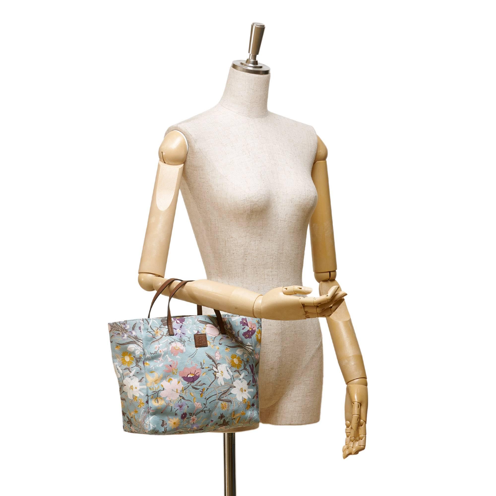 - This Gucci blue multi coloured tote bag features a floral printed canvas body, flat leather handles, open top, and interior slip pocket. 

- Made in Italy. 

- Size: 24cm x 21cm x 10cm. 

- Include: Dust bag. 

- Condition: Excellent. 