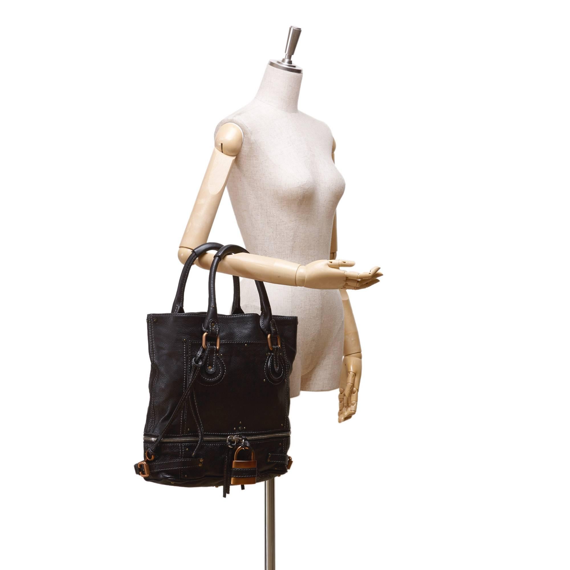 - Diese berühmte schwarze Paddington-Tasche mit Reißverschluss von Chloe hat einen Korpus aus Leder:: gerollte Griffe:: ein übergroßes:: charakteristisches Vorhängeschloss mit goldfarbener Hardware:: ein separates Reißverschlussfach unten:: eine