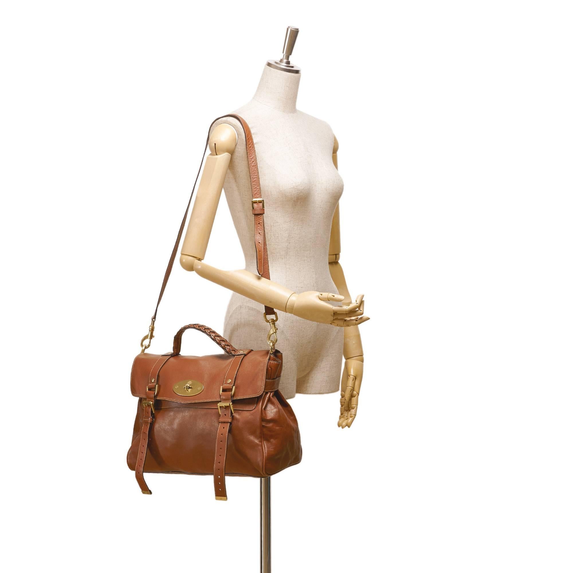 - This Mulberry brown Alexa shoulder bag features a leather body with belt details, a detachable adjustable shoulder strap, gold-tone hardware, a braided top handle, a front flap with a twist-lock closure, and interior zip and slip pockets.

- Made