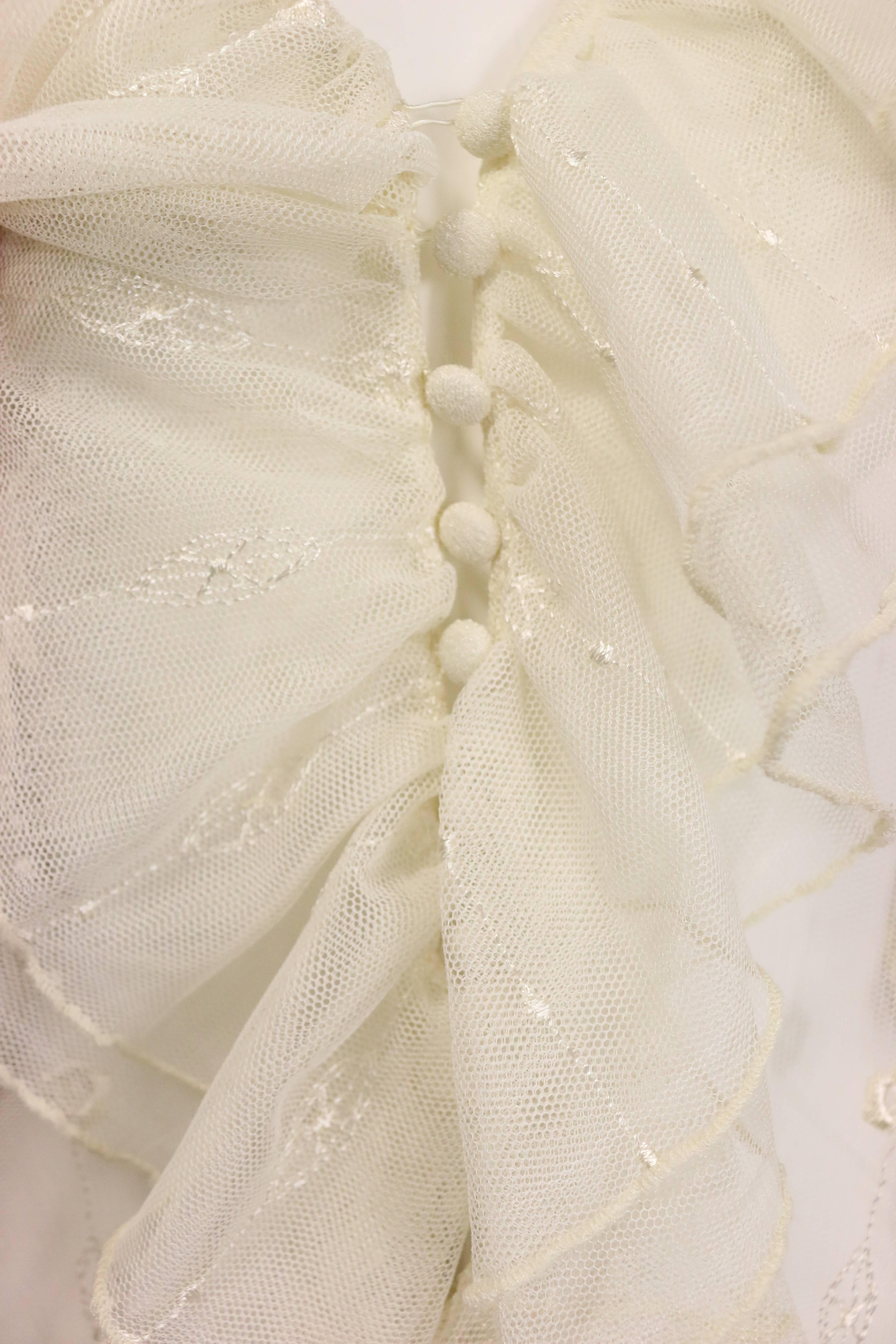 - Vintage 90s Nouvelle Couture Ivory poly netting ruffle shirt. Featuring embroidered flower and patterns with ruffle cuff. Seven front buttons fastening. 

- Made in USA. 

- Size Medium. 



