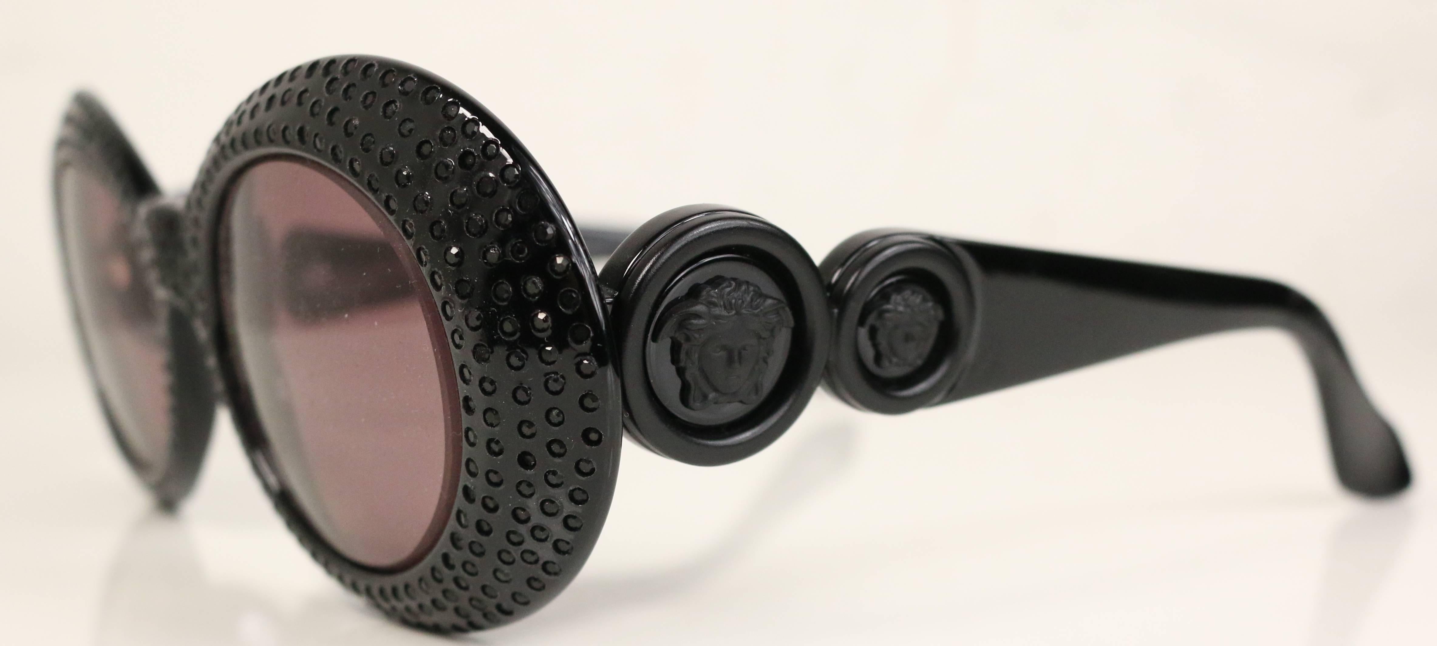 - Vintage Gianni Versace black oval sunglasses with black sapphires. Featuring two signature black 