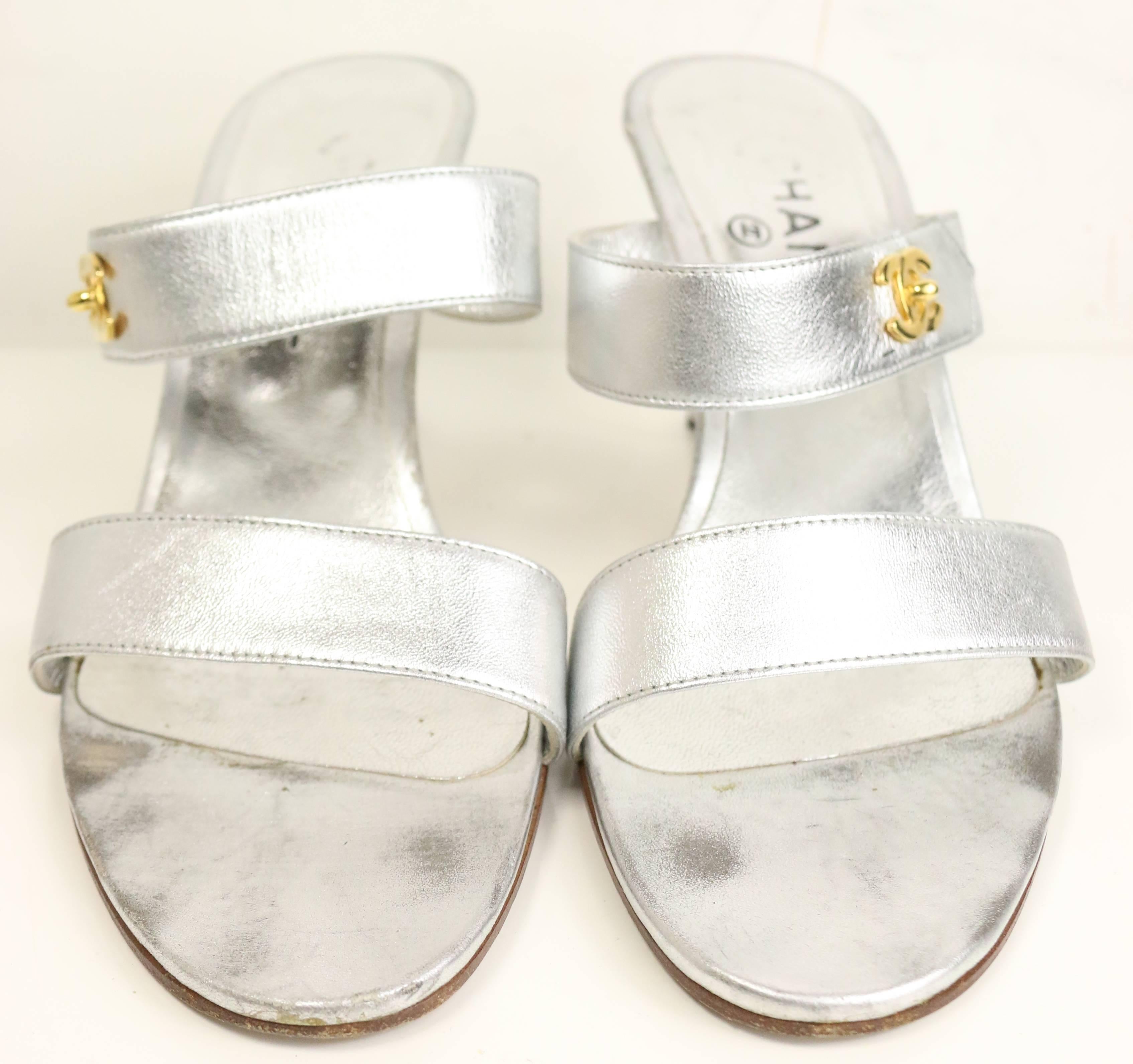 - Vintage 90s Chanel silver metallic leather straps sandals heels. Featuring a gold toned hardware 
