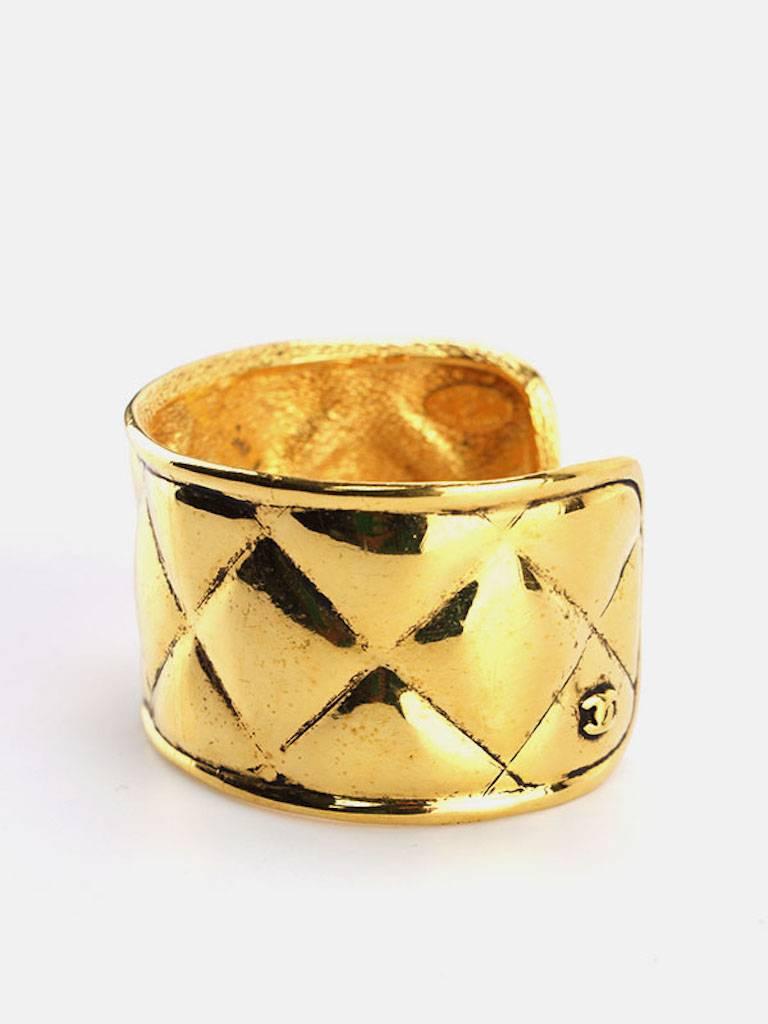 - Vintage 90s Chanel gold toned plate quilted wild cuff bangle. Unique and elegant to wear it with your casual wear or an evening night out. 

- Made in France. 

- Inner diameter: 6.5 x 5.5 cm (2.56 x 2.17 inches). 

- Outer circumference: 20.5 cm