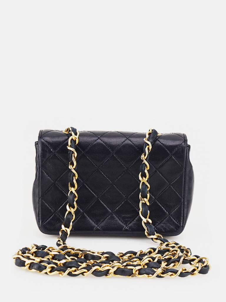 - Vintage 90s Chanel black quilted lambskin mini flap shoulder bag. Featuring a gold toned "CC" turnlock closure, a gold chain hardware leather shoulder strap. A classic Chanel black mini is a gem!

- Made in France.

- Size: W 5.7 × H 3.6