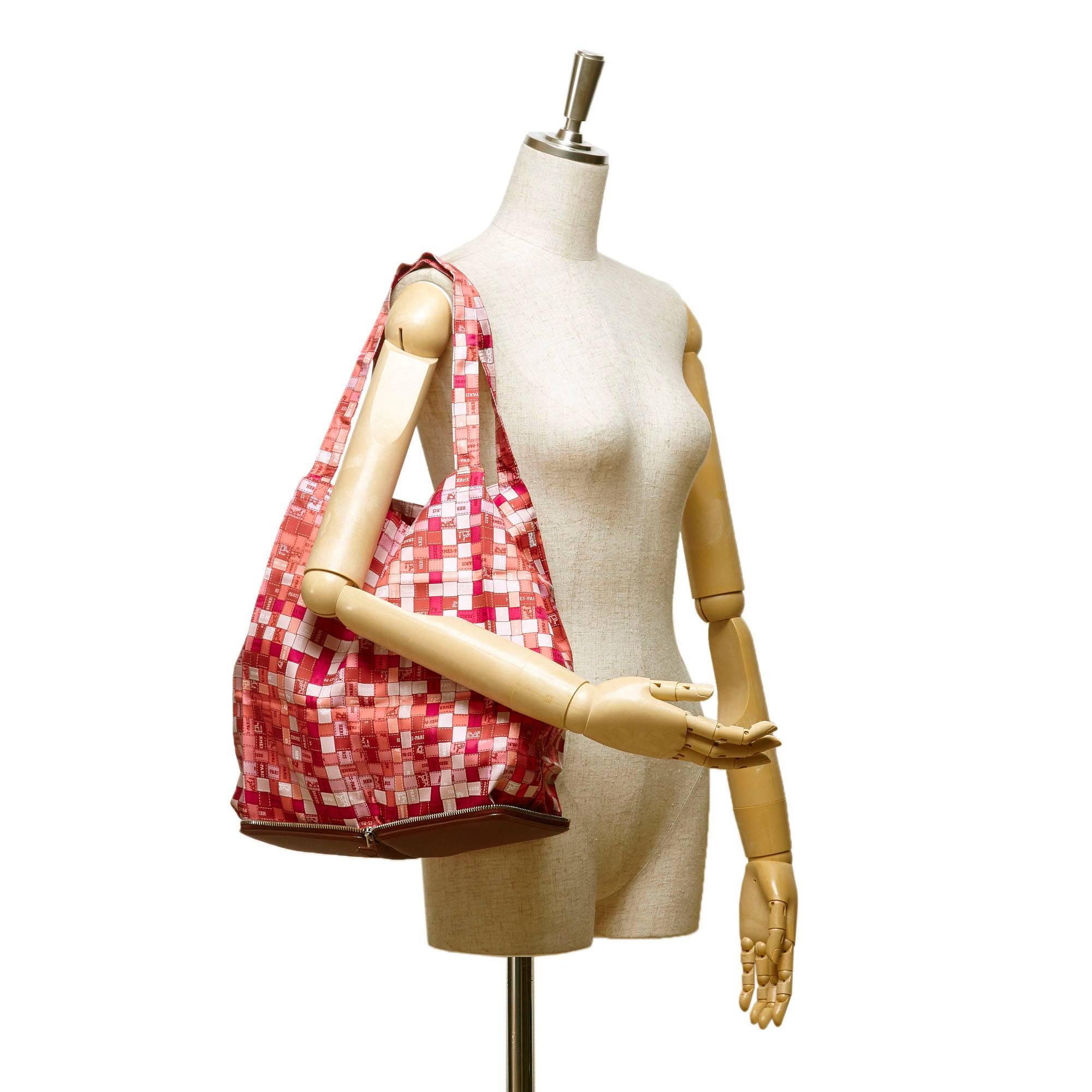 - These Hermes pink, red and white horse theme printed canvas silky top tote bag features a silk body, flat handle, open top, and a red leather casing with zip around closure. A luxury and chic bright colour shopping bag!

- Made in France. 

-