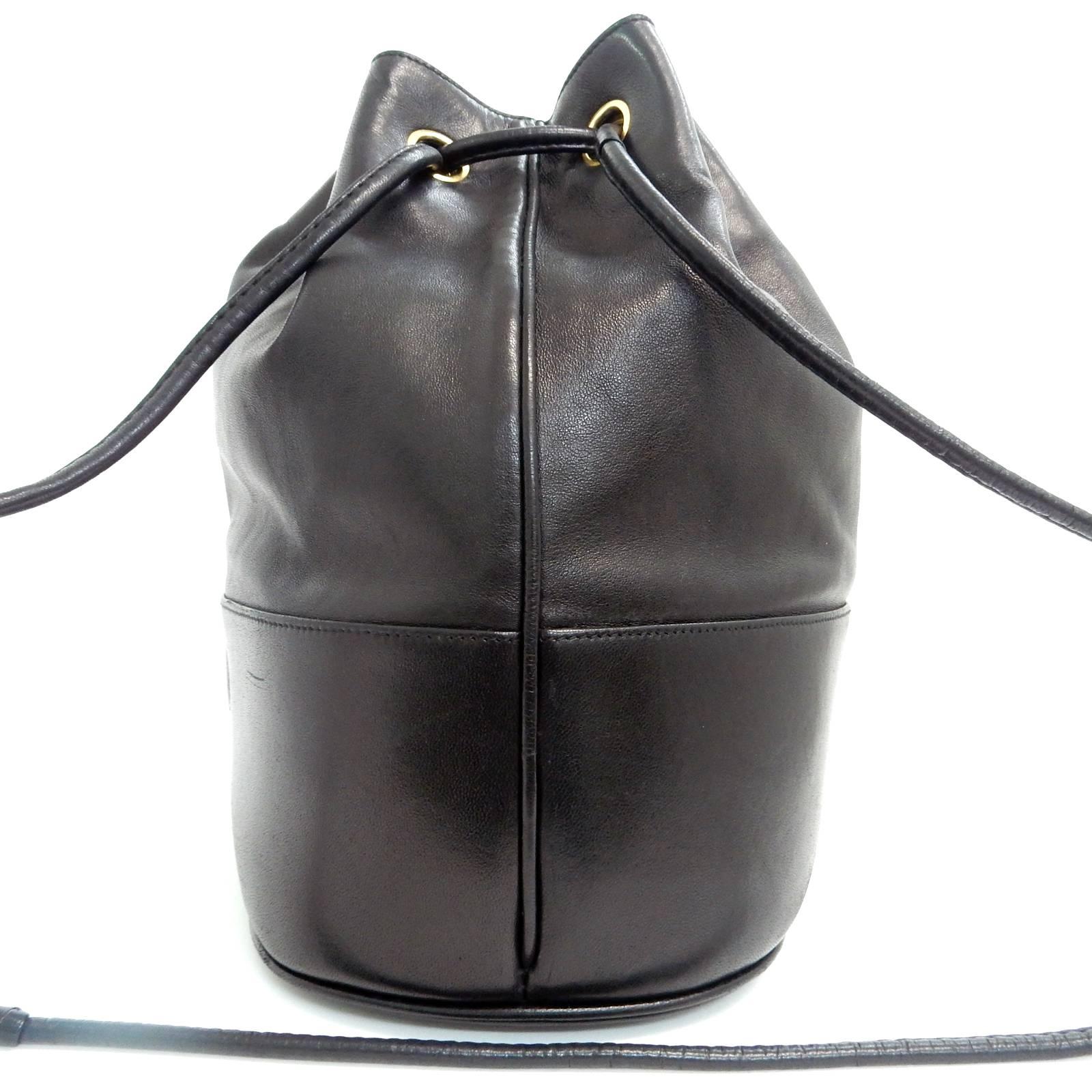 - Vintage early 90s Chanel black lambskin leather drawstring bucket shoulder bag with a pouch bag. Featuring a black "CC" logo on the base of the bag, two gold toned hardware "CC" logo drawstring closure. A very chic and classic