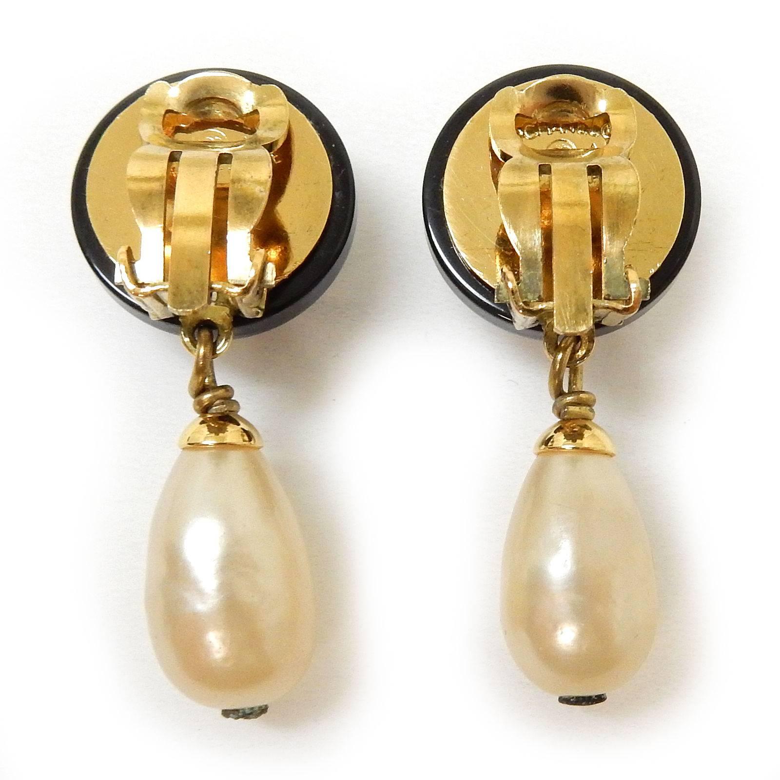 - Vintage 1994A Chanel classic black with gold toned hardware "CC" faux pearl drop clip on earrings. A very classic earrings that is a collectable item. 
  
- Made in France. 

- Earring Diameter : 9/16 inches (14mm) 
  Earring Length :