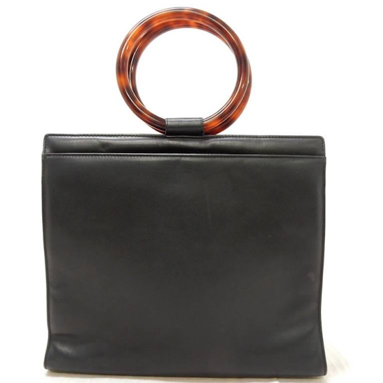 - Vintage 90s Chanel black lambskin leather with tortoiseshell handle handbag.  Featuring double tortoiseshell handles, one interior leather zipper pocket and one interior slip pocket.  The bag looks very retro with the round shape handle! 

- Made