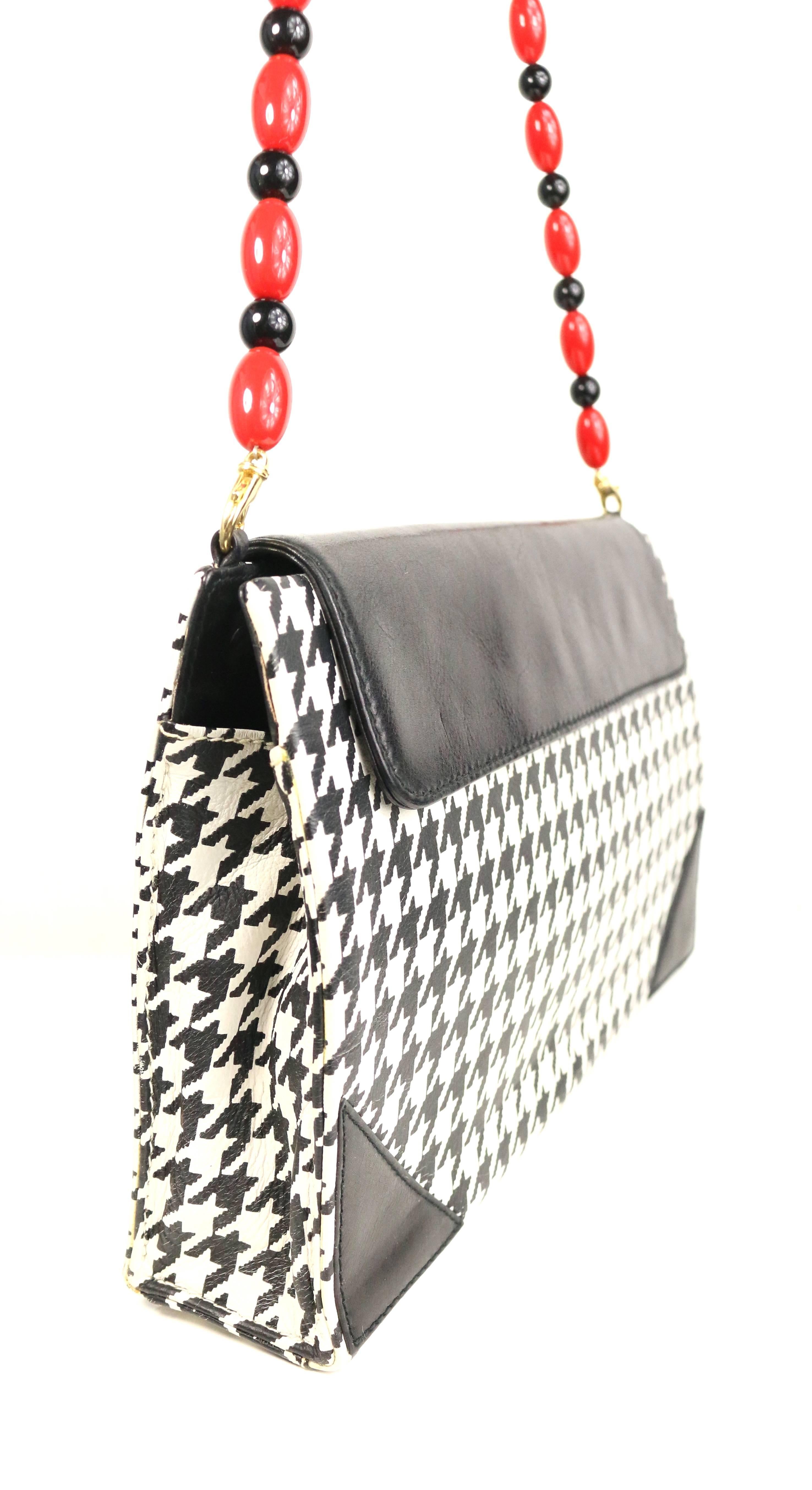 - Vintage 80s RoccoBarocco rectangle black and white shepherd's check small flap shoulder bag. Featuring a detachable black and red shoulder strap, one interior zipper pocket and one interior open pocket. 

- Made in Italy. 

- Length: 10.5 inches.
