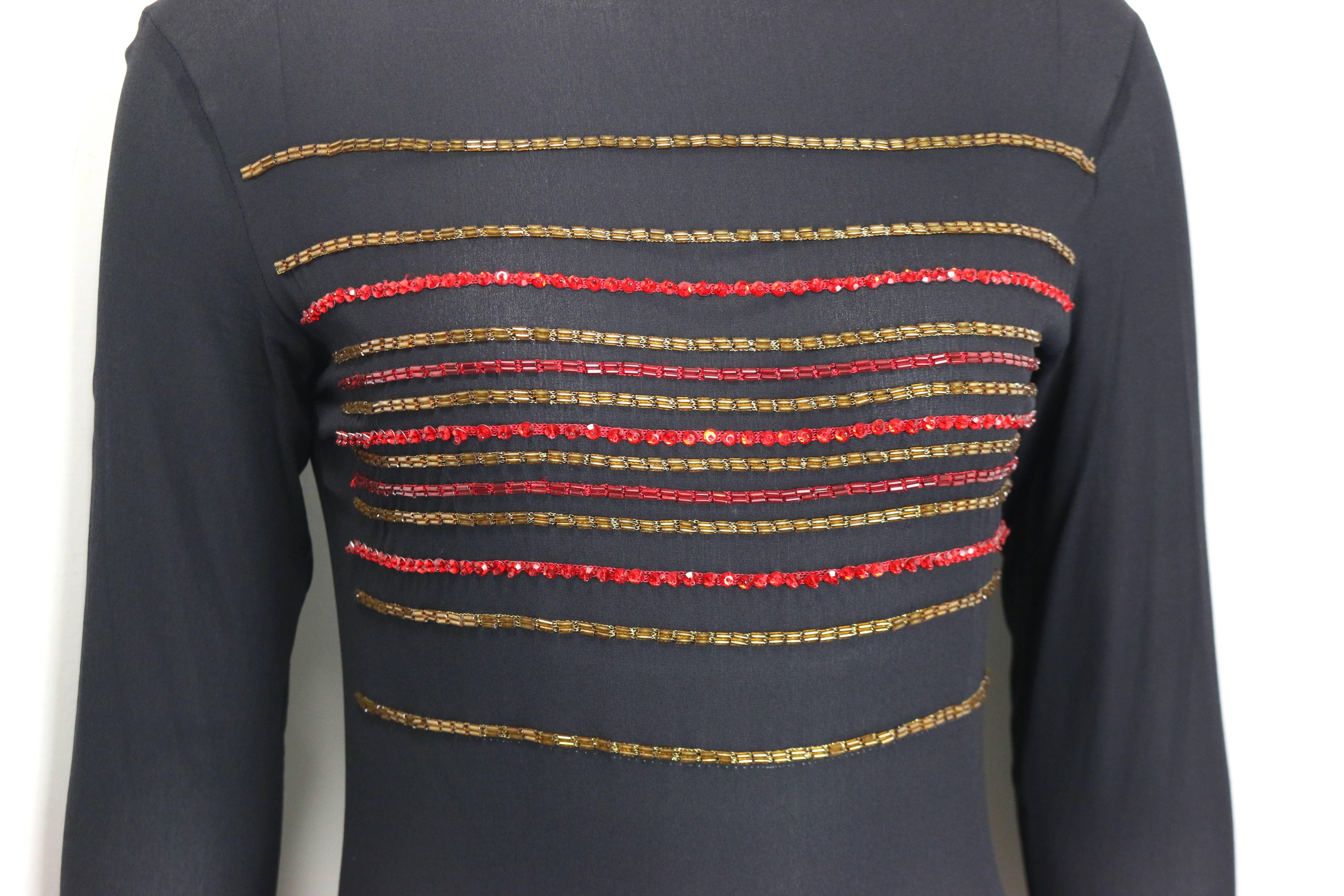 - Vintage 90s Gianni Versace couture black see through silk long sleeves bodysuit. 

- Featuring gold and red beads across the front body,  and red beads neckline trim. 

- Green and blue beads trim on the cuff with three gold toned 