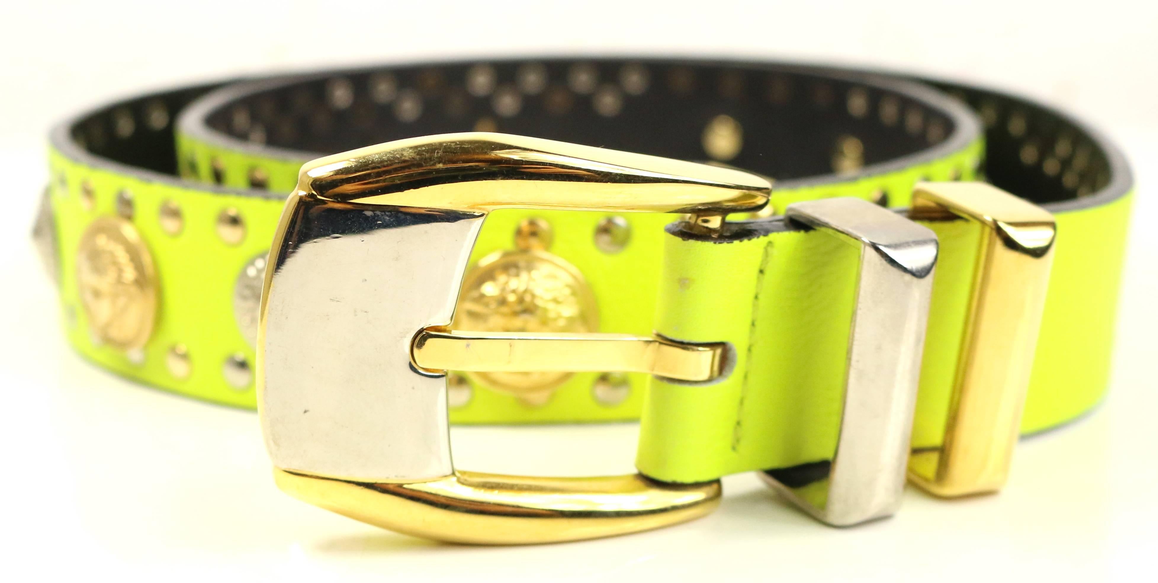 - Vintage 90s Gianni Versace neon green/yellow lambskin leather with gold and silver studs belt. 

- Featuring embedded gold toned Medusa and silver toned shield studs. 

- Gold and silver toned hardware buckle fastening. 

- 37 inches long and 1.5
