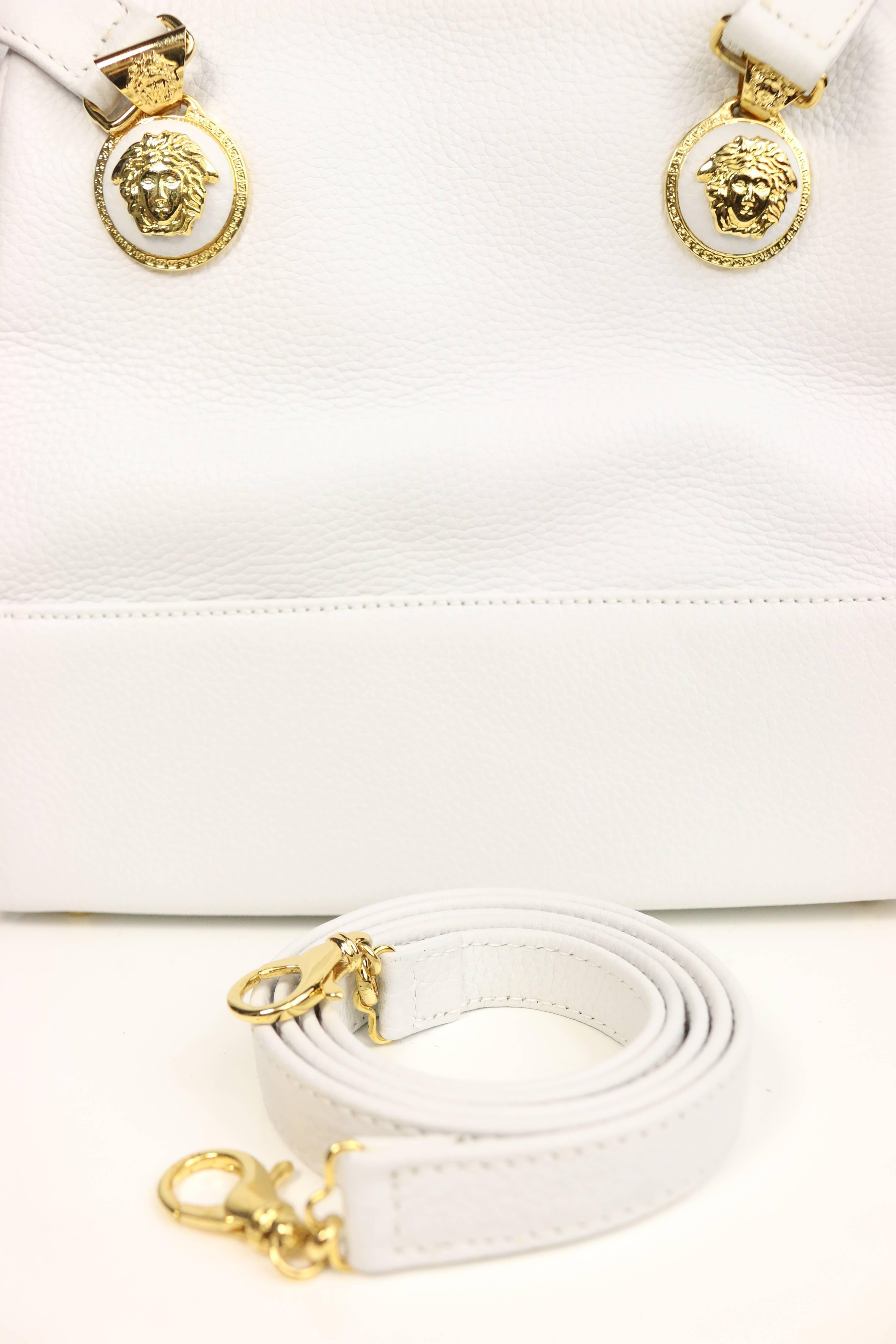 - Vintage 90s Gianni Versace Couture white leather Handbag. 

- Gold toned hardware Medusa zip closure. 

- Interior zip closure. 

- Five bottom gold toned hardware studs. 

- Height: 8 inches. Length: 8.5 inches. Width: 2.5 inches. Hand Drop: 8