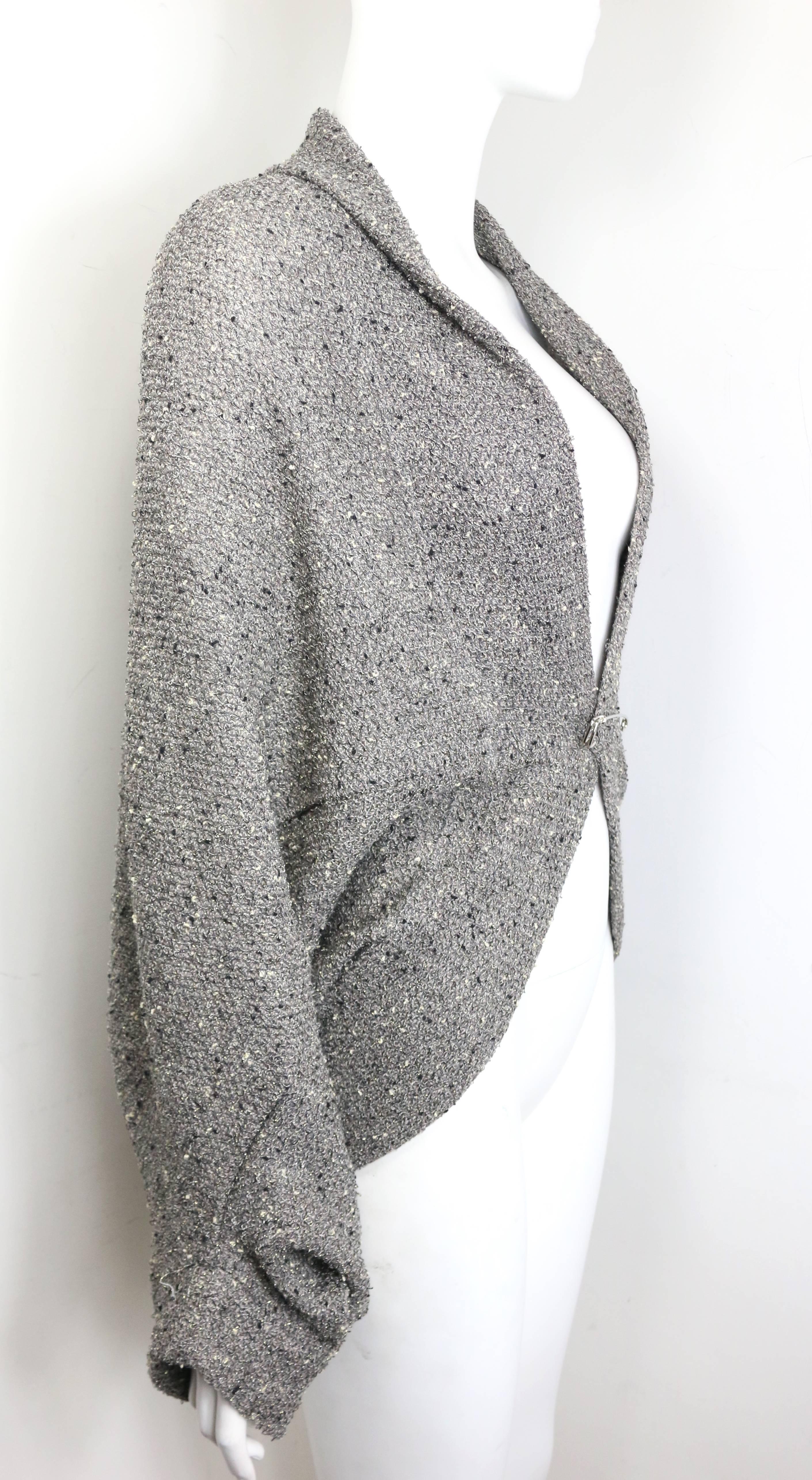 - Limi Feu grey knitted wool bolero cardigan. 

- Featuring a silver pin fastening. 

- Light tweed fabric with some silver metallic wire.

- The designer father is Yohji Yamamoto. 

- Free Size. 

- 57% Wool, 26% Cotton, 9% Nylon, 7% Rayon, 1%