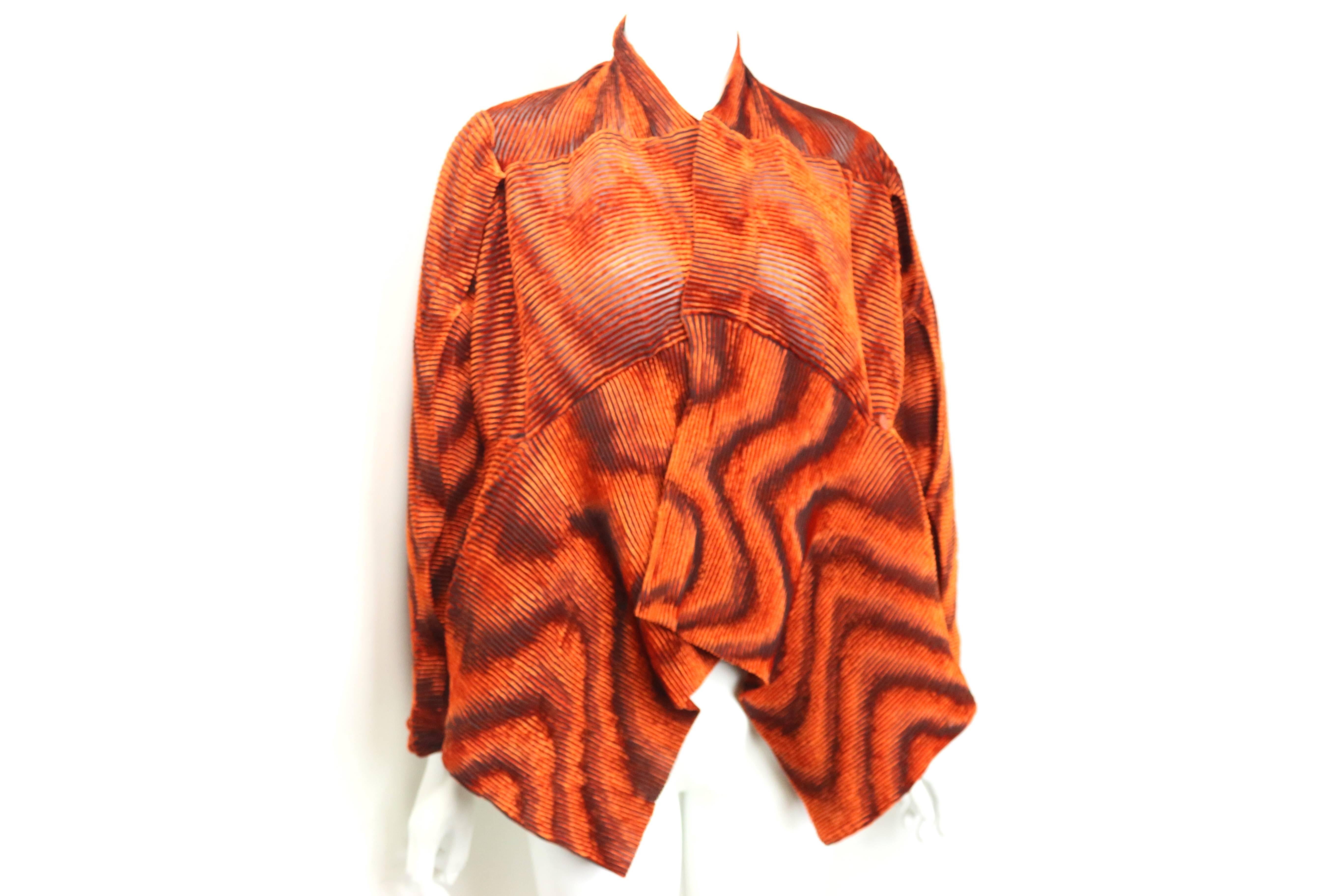 - Vintage 90s Issey Miyake orange velvet plasma wave pleated bolero jacket.

- Top can be styled in various ways dues to its elasticity.  

- Four shoulder slits for different styling of the jacket. 

- Small button closure. 

- Size Small.

- 50%