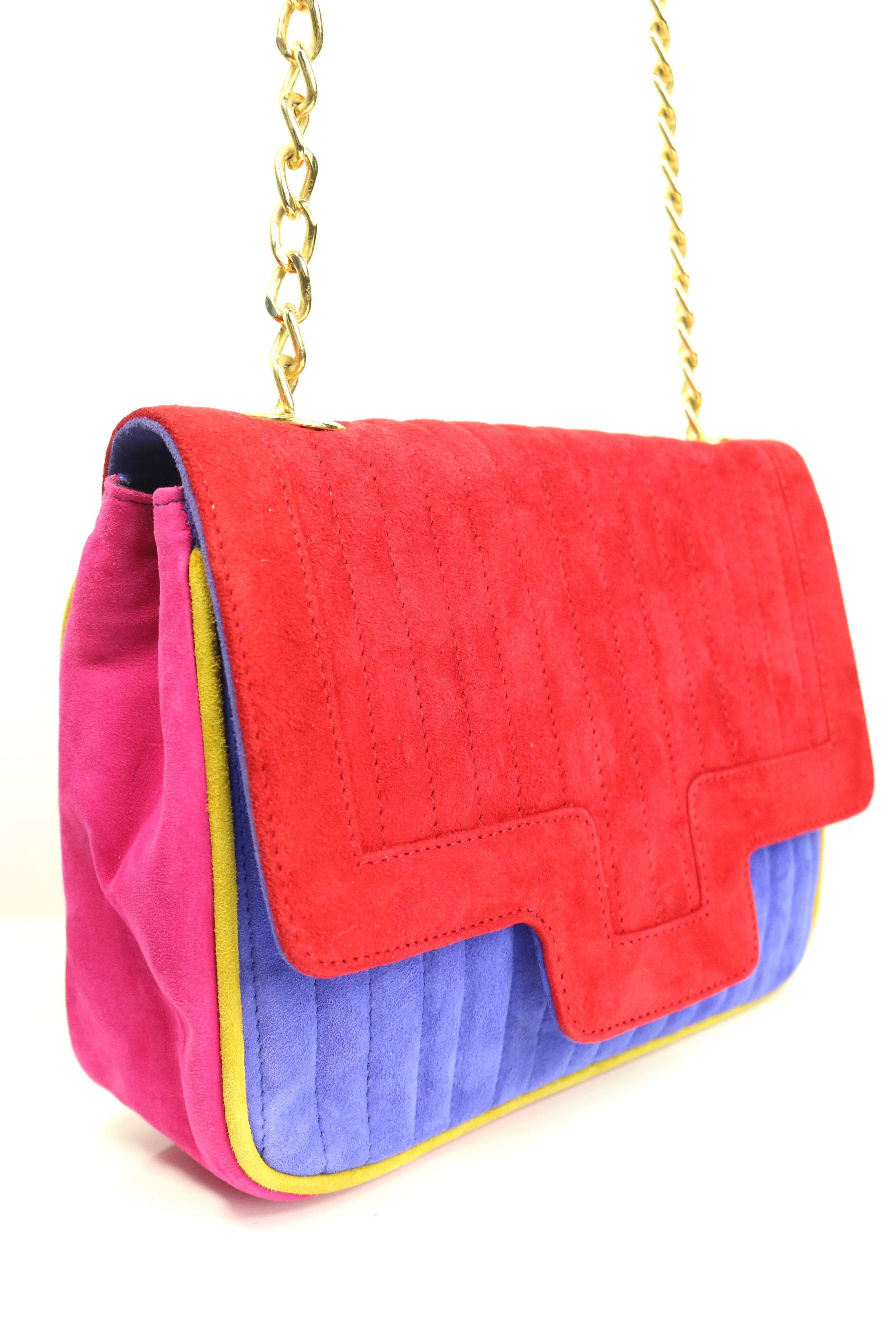 - Vintage 80s Pancaldi colour blocked (red, blue. pink and yellow trim) suede flap shoulder bag. 

- Featuring a gold toned chain attached with the black suede shoulder strap. 

- Flap with snap button closure. 

- Interior zip closure. 

- Length: