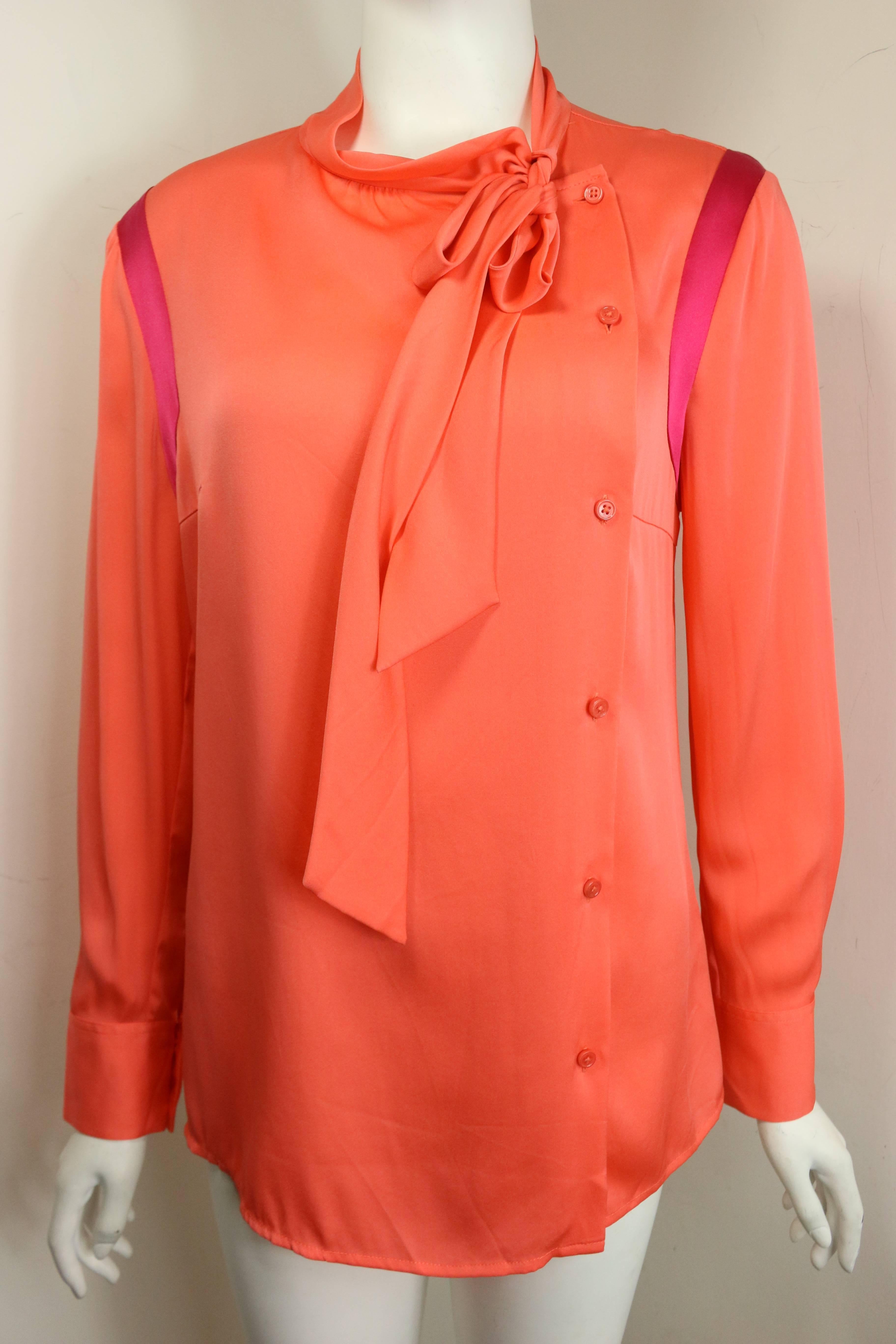 - Ports orange silk button shirt. Pink panels on the shoulder sleeves. 

- Featuring collar can be tied as a ribbon. Buttons fastening on the left. 

- Size 8. 

- 100% Silk. 
