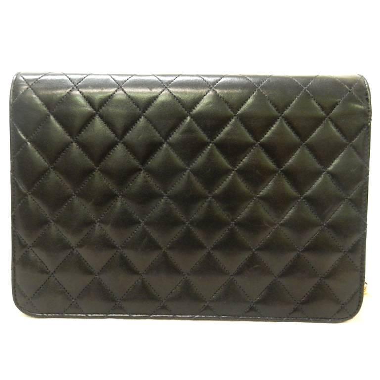- Vintage 1997 to 1999 classic Chanel black quilted lambskin leather flap shoulder bag with gold chain leather strap. 

- A small pin snap button closure. 

- Interior pocket zip closure. 

- Height: 7 inches. Length: 12 inches. Width: 2 inches.