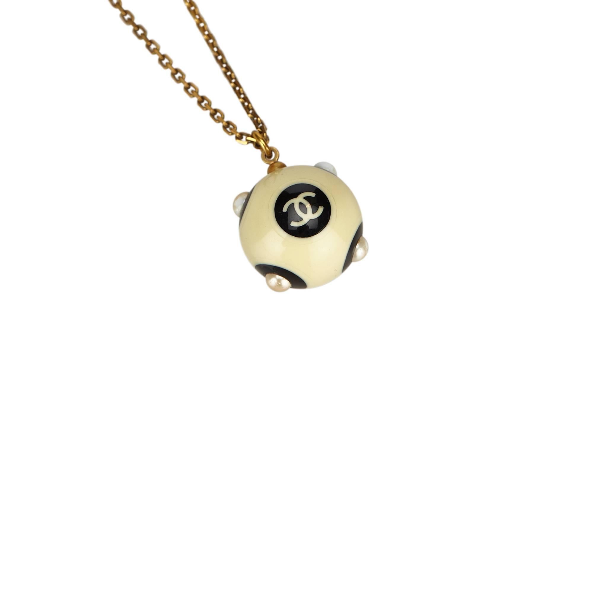 - Chanel Ivory x Black with faux pearl studs ball pendant necklace from 2002A collection. 

- Featuring a gold-tone neck chain, and a back hook closure.

- Ball: 1.8x 1.8 diameters. Chain Length: 46cm.

- Condition: Material is slightly scratched