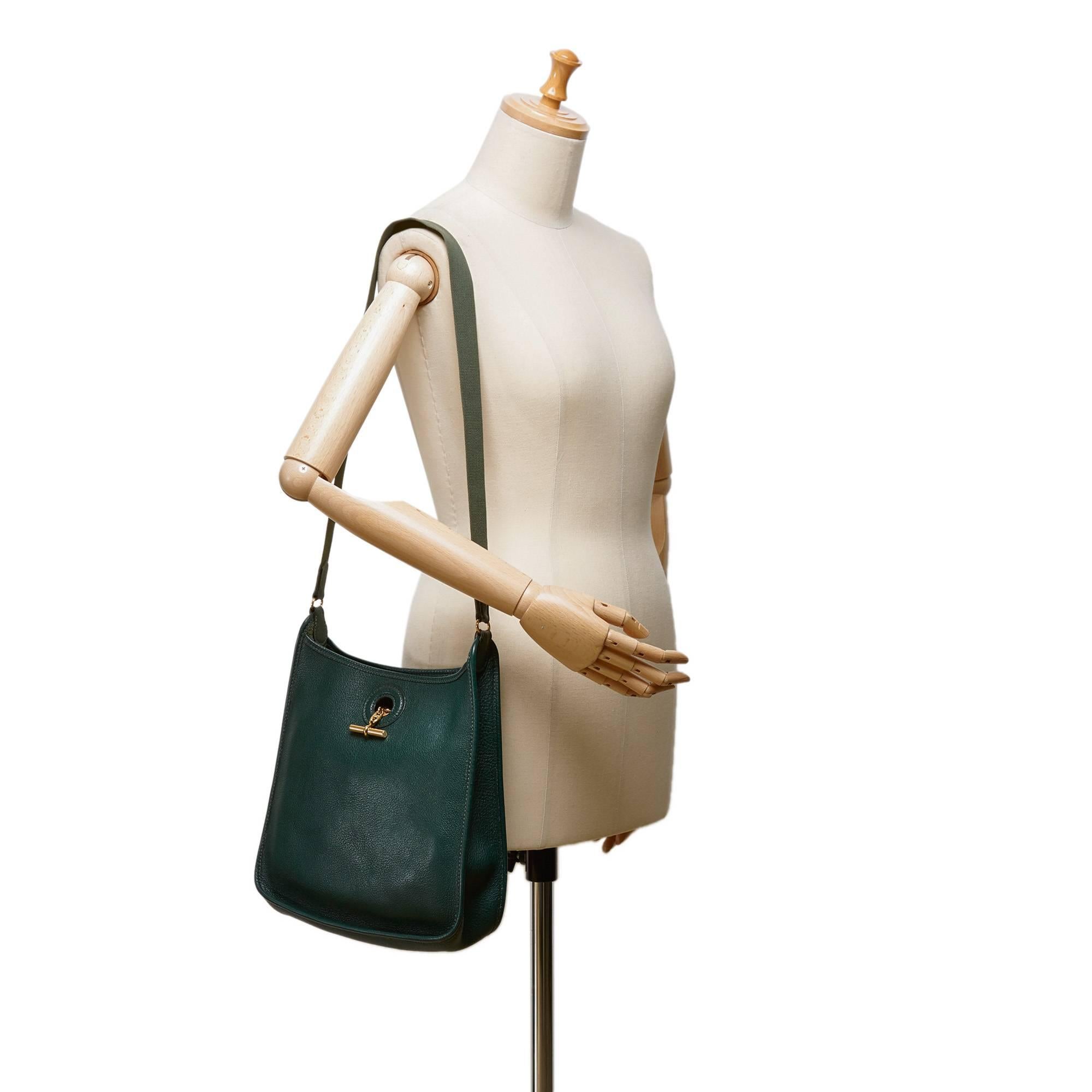 - Hermes green leather Vespa Pm shoulder strap bag.  

- Featuring a top bar and ring closure.

- An interior slip pocket.

- Length: 28cm. Height:  27cm. Width: 7.5cm. Shoulder Strap: 47cm. 

- Included: Dust bag. 

- Condition: Excellent. We would