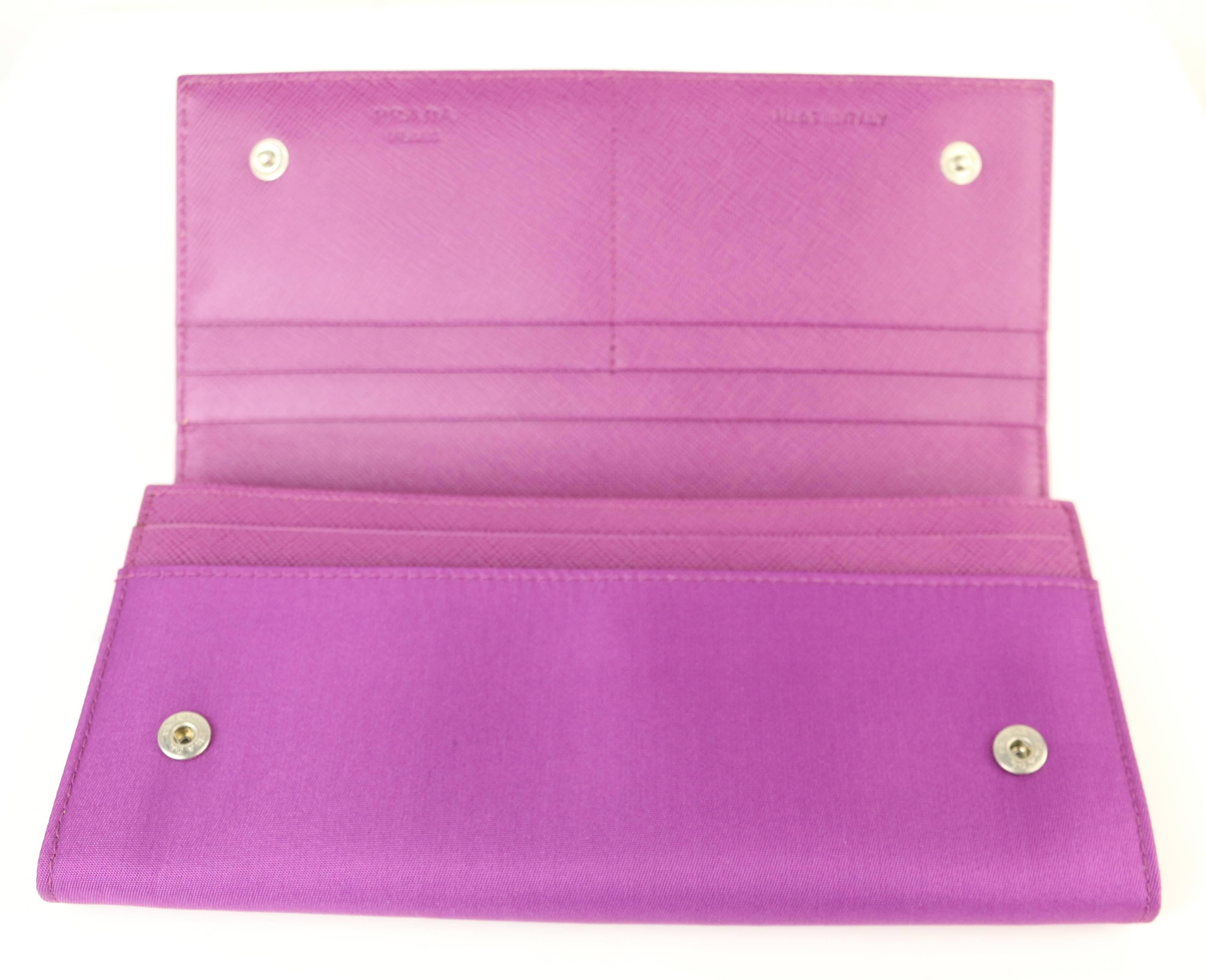 - Prada purple polyester wallet. 

- Compartments for containing cards, money, and coins etc... 

- Snap buttons closure. 

- Length: 7.5 inches. Height: 3.5 inches. Widht: 0.75 inches. 

