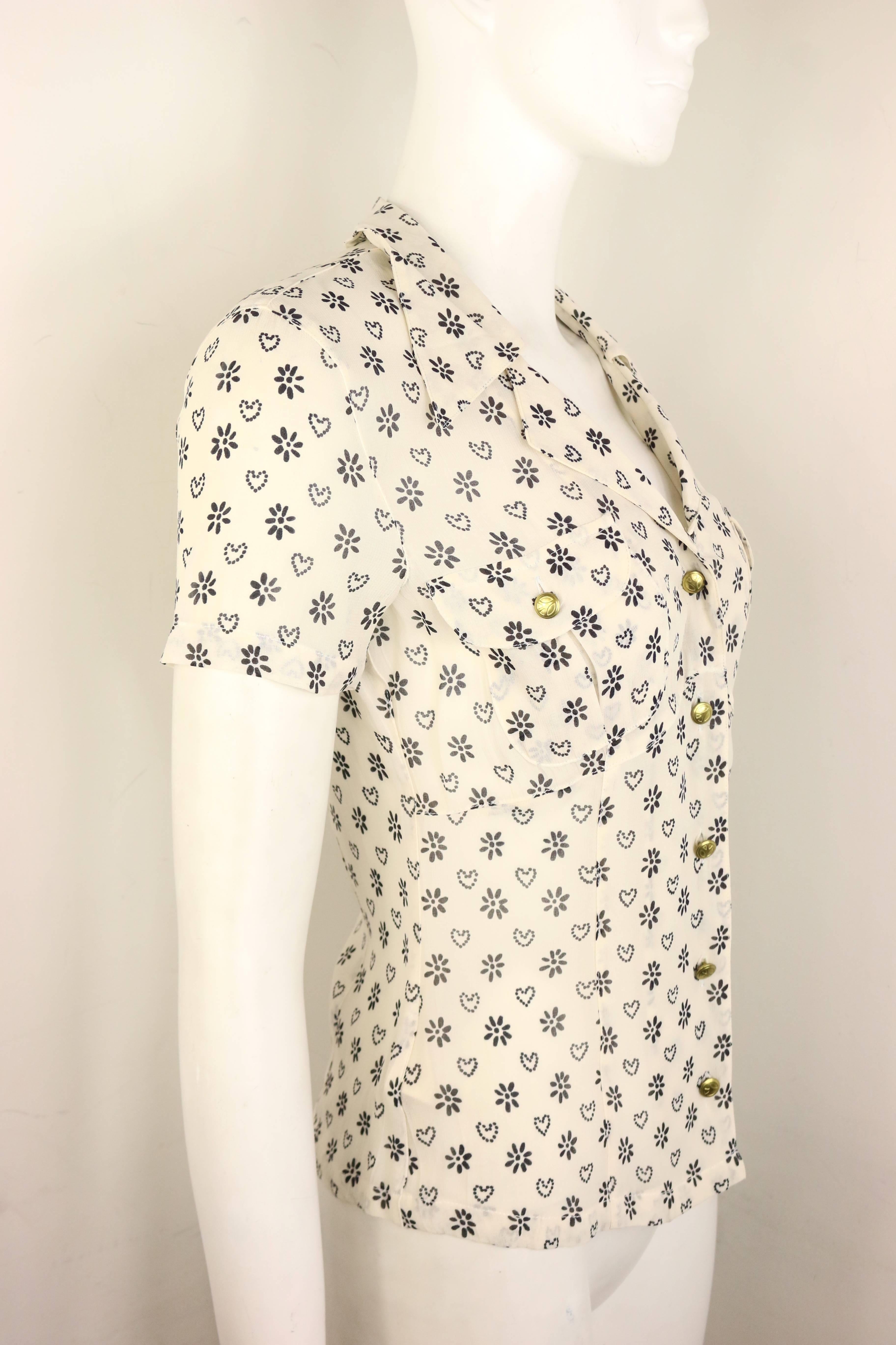 - Vintage 90s Moschino Jeans weißes Hemd mit kurzen Ärmeln und Kragen. 

- Mit schwarzem Sonnenblumen- und Herz-Print, goldfarbenen 